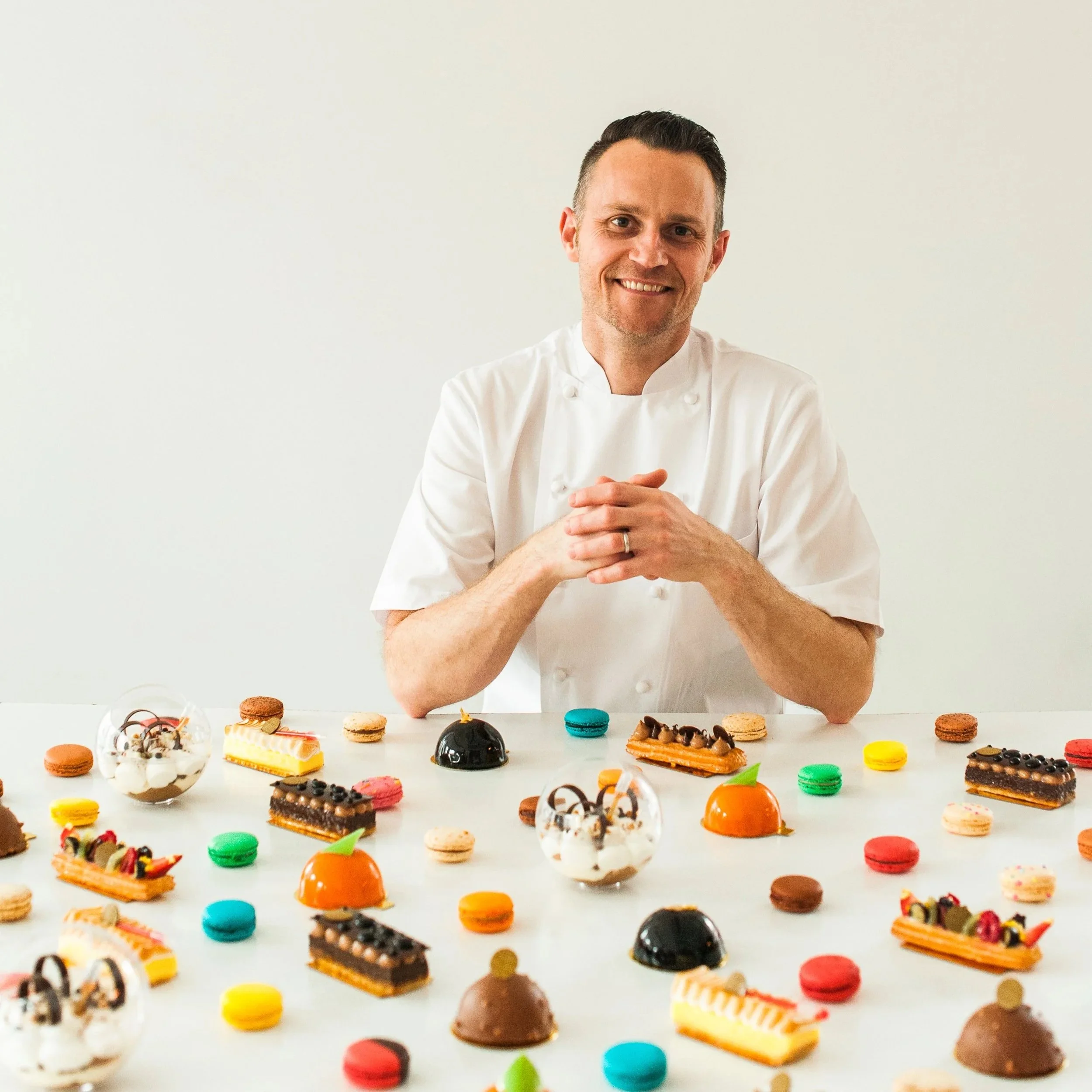 Chris Hammer smiling at camera with multiple pastries.