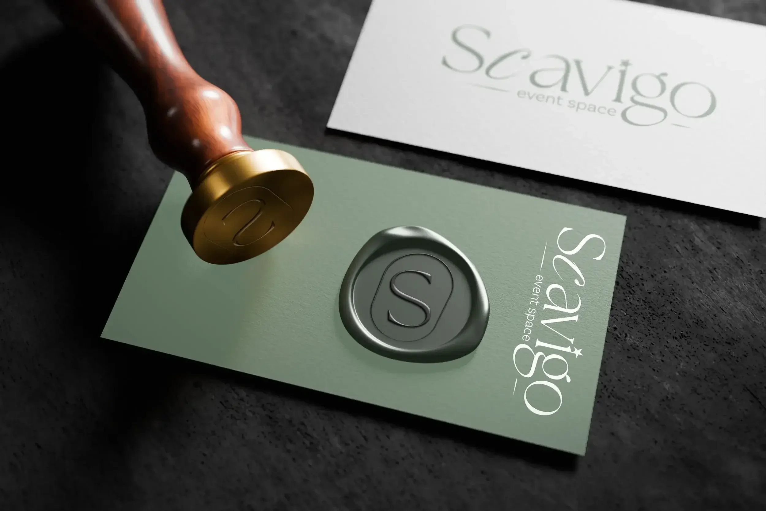 A wax stamp of a "S" in an oval on a Scavigo Event Space business card