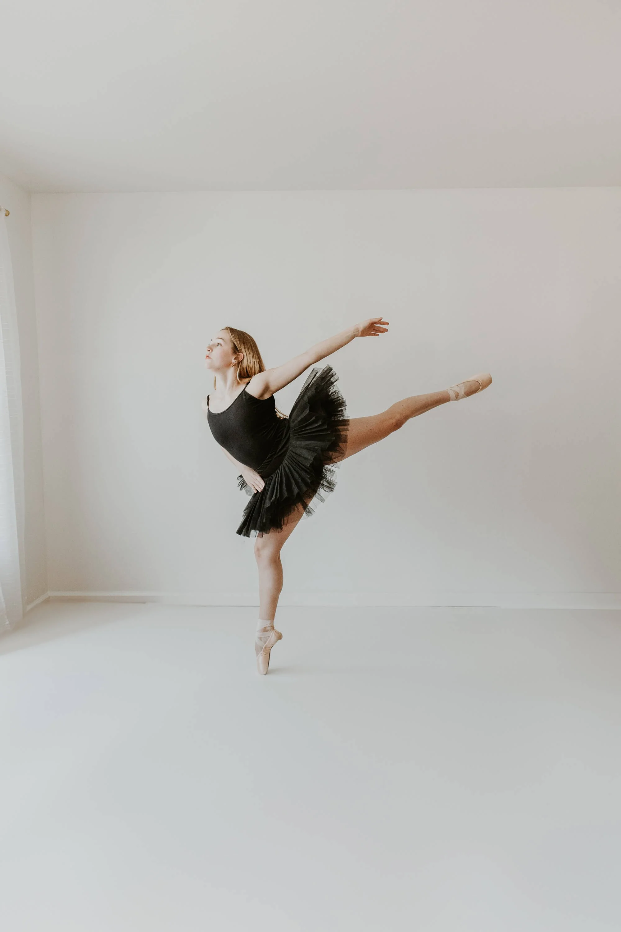 A strong and talented high school ballerina holds her foot in a balanced en pointe position.