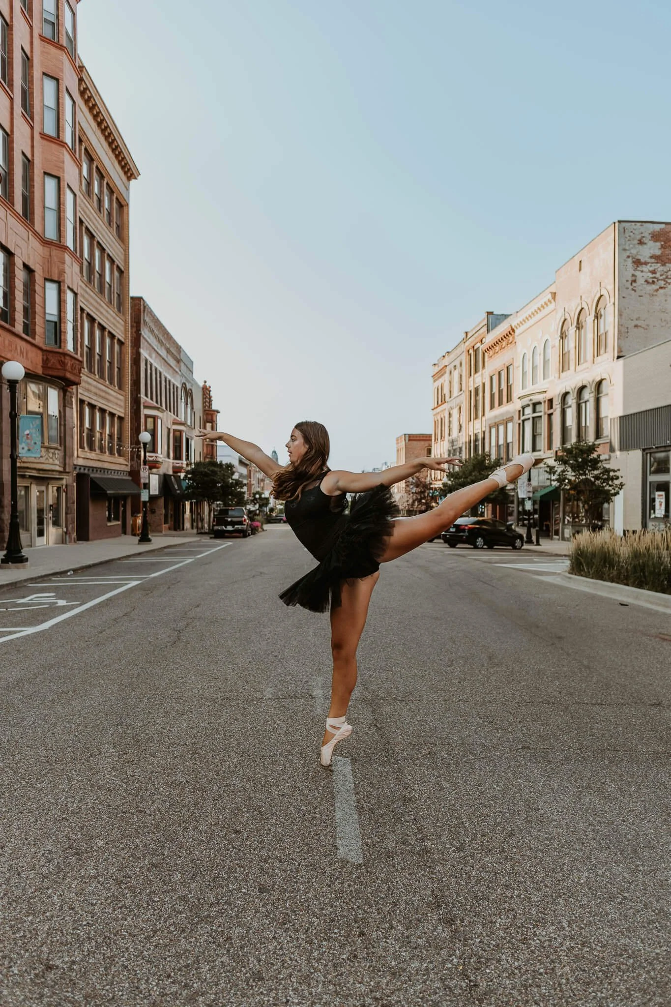 A 17 year old ballet dancer holds a pose en pointe on main street in Downtown Bloomington, IL