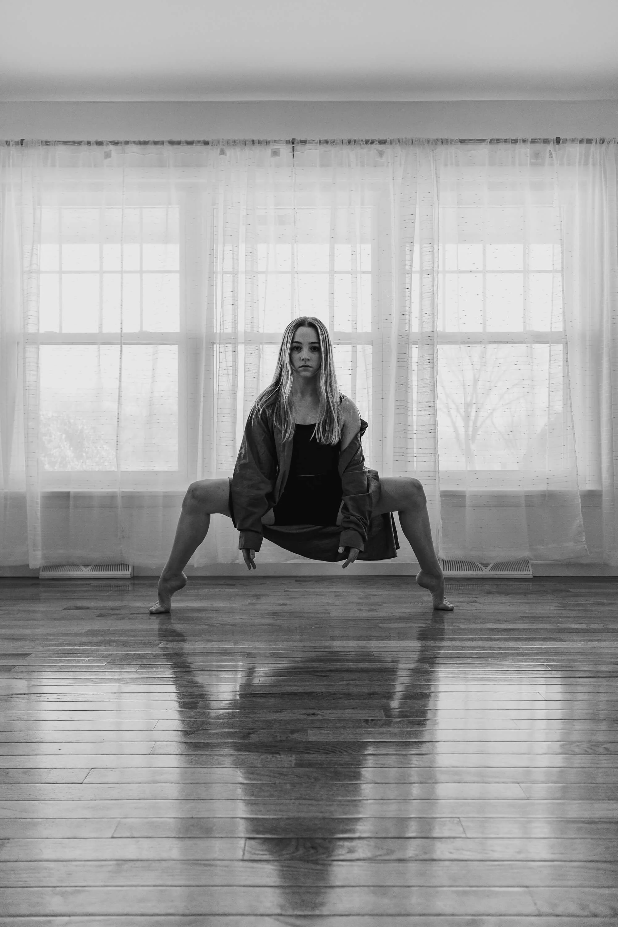 A black and white image of a dancer in second position.