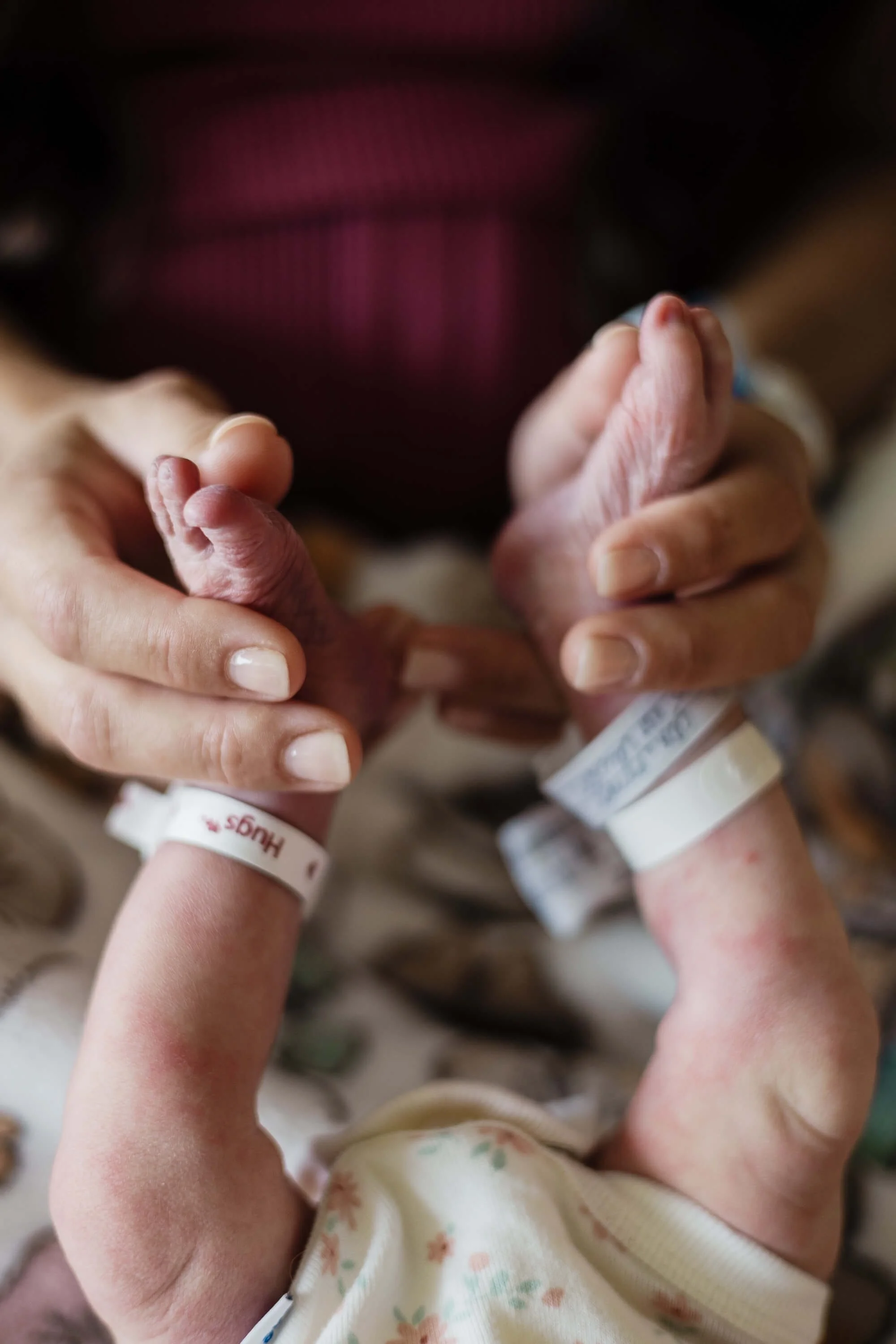 A mother gently holds her new daughter's feet
