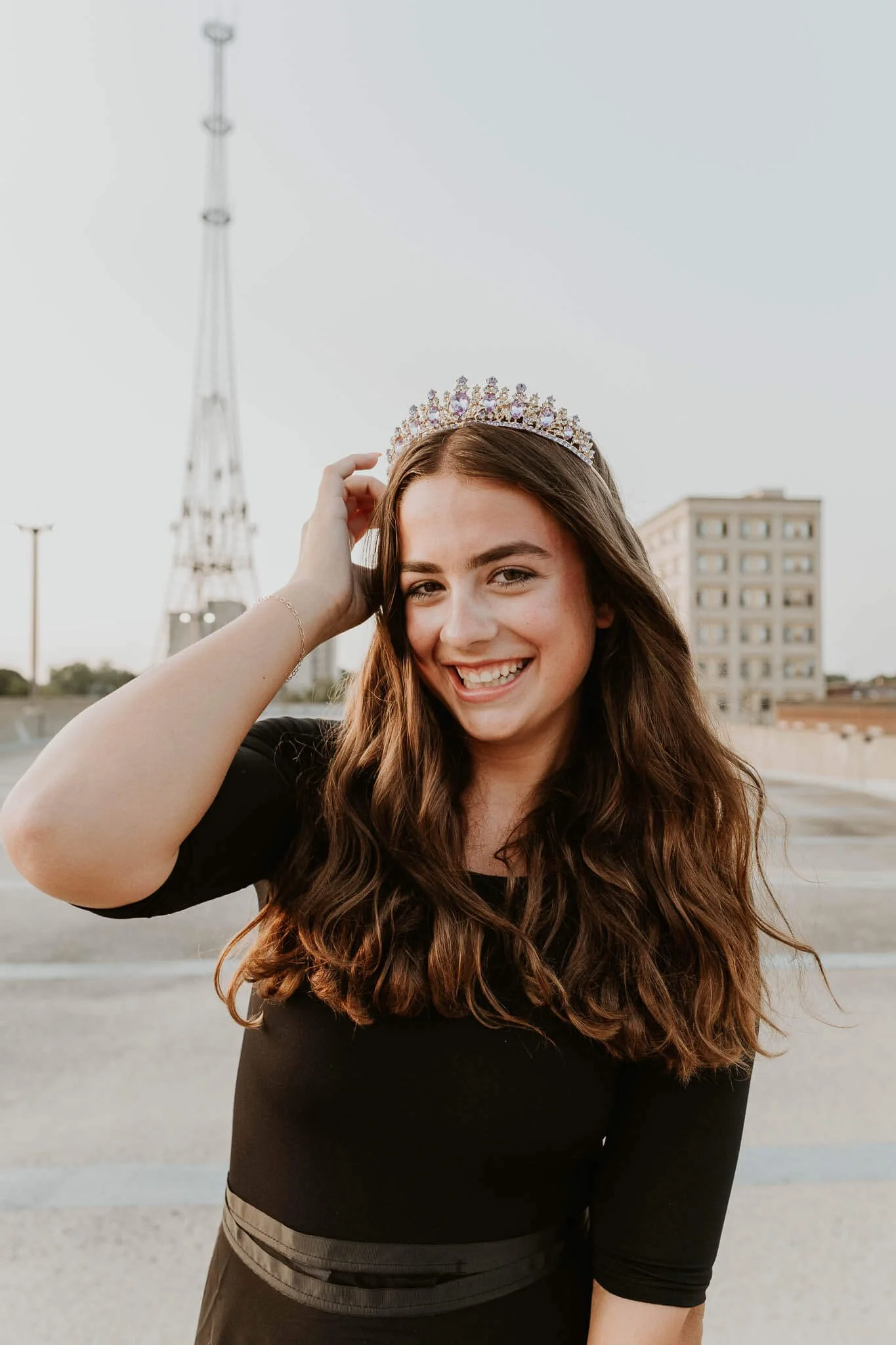 A dancer holds a pose, tucking a strand of hair behind her ear for a close up portrait