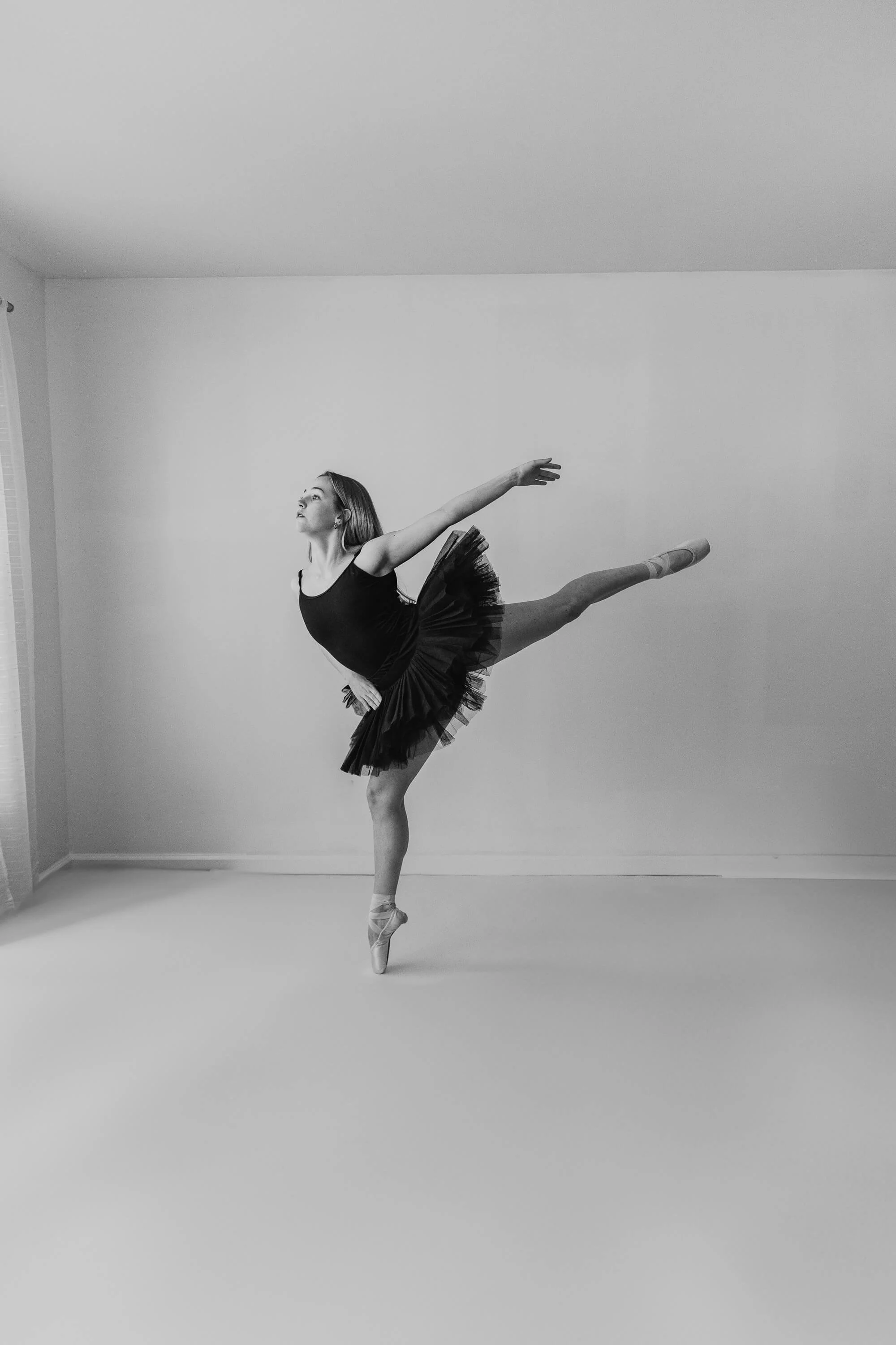 A black and white of a dancer balancing on one foot.