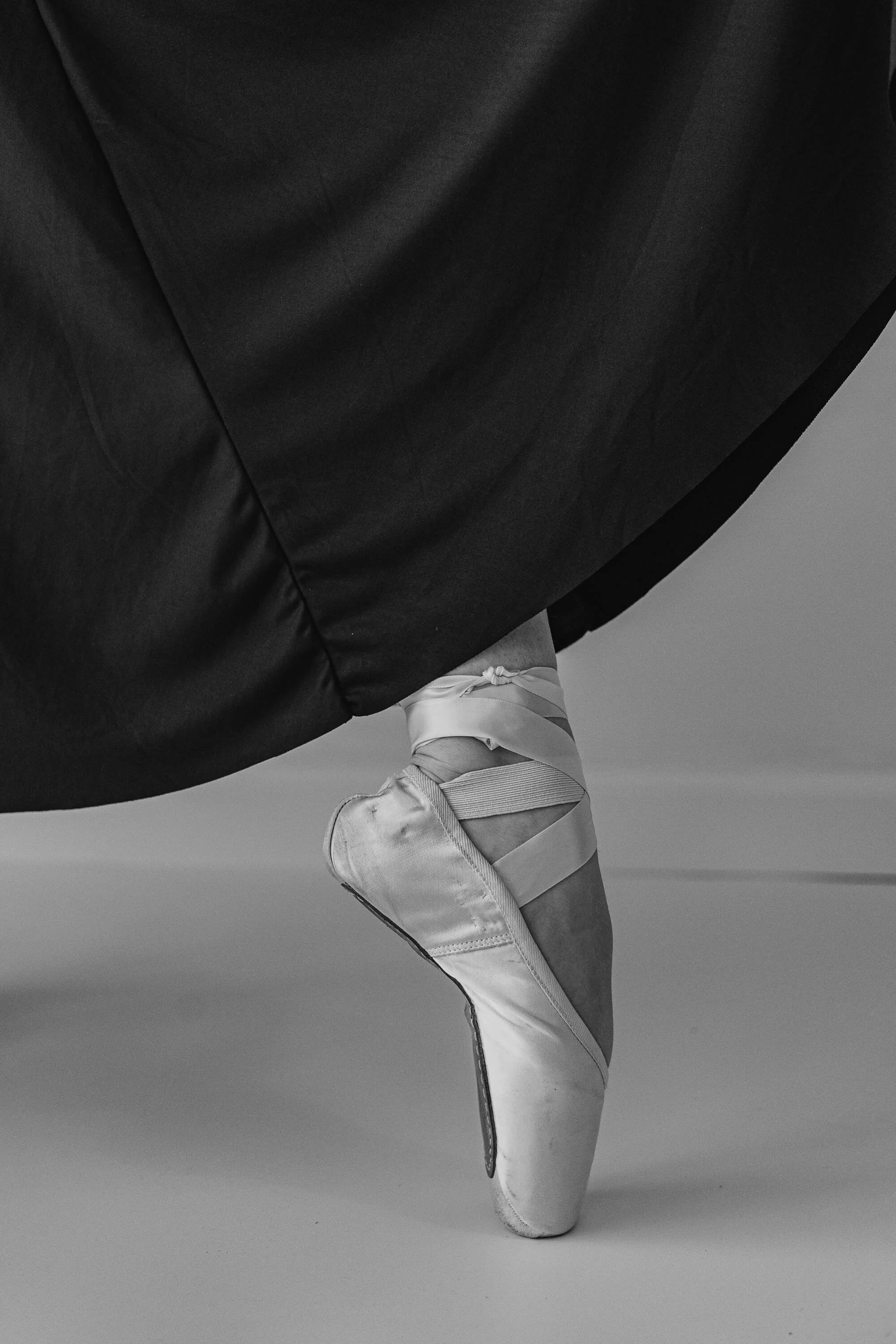 A black and white of the profile of a pointe shoe.