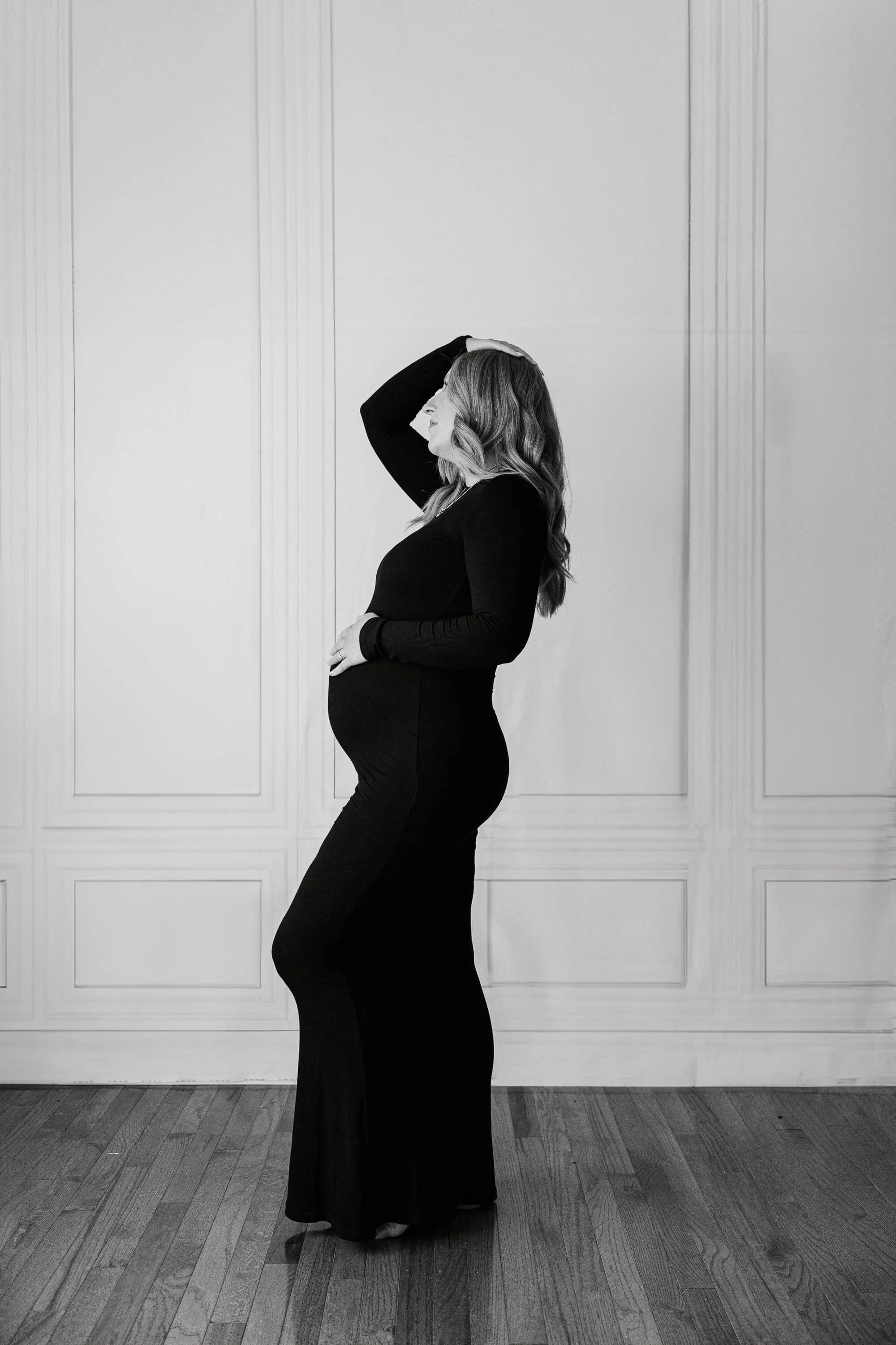 A pregnant mom dressed in a fitted black dress