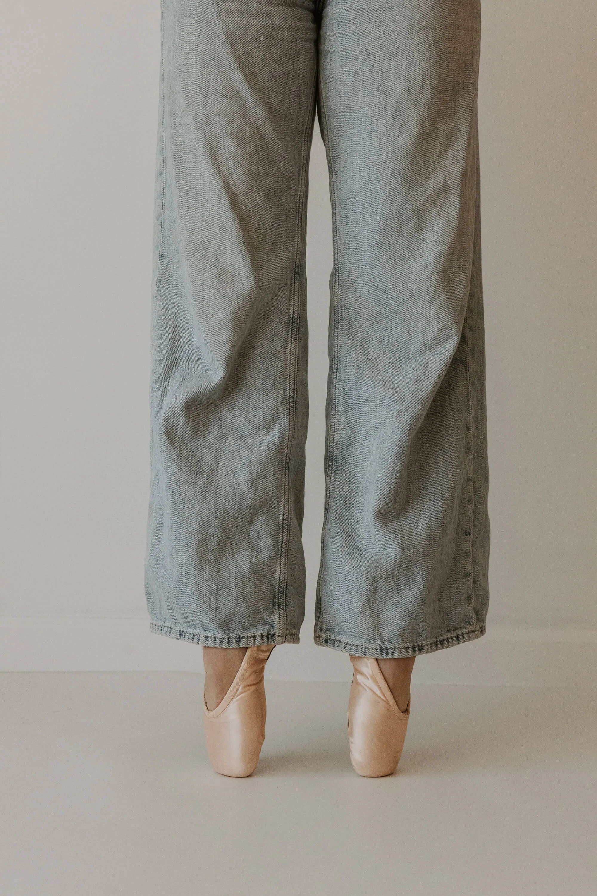 A portrait close up of a ballet dancer in first position en pointe.