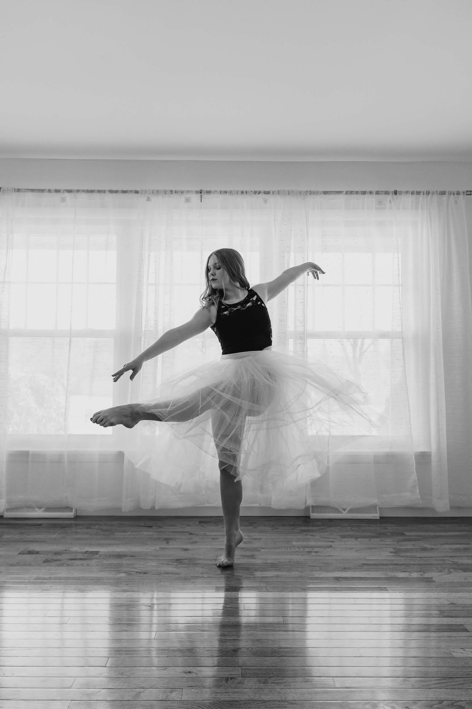 A black and white image of a dancer balancing on one leg.
