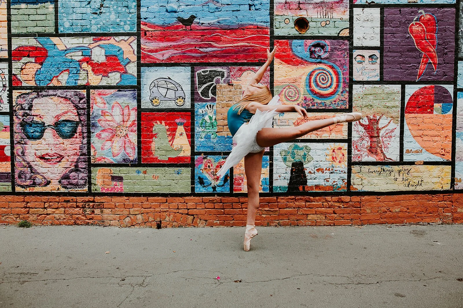 A dancer en pointe stands in front of the well-known, colorful mural in Uptown Normal, IL