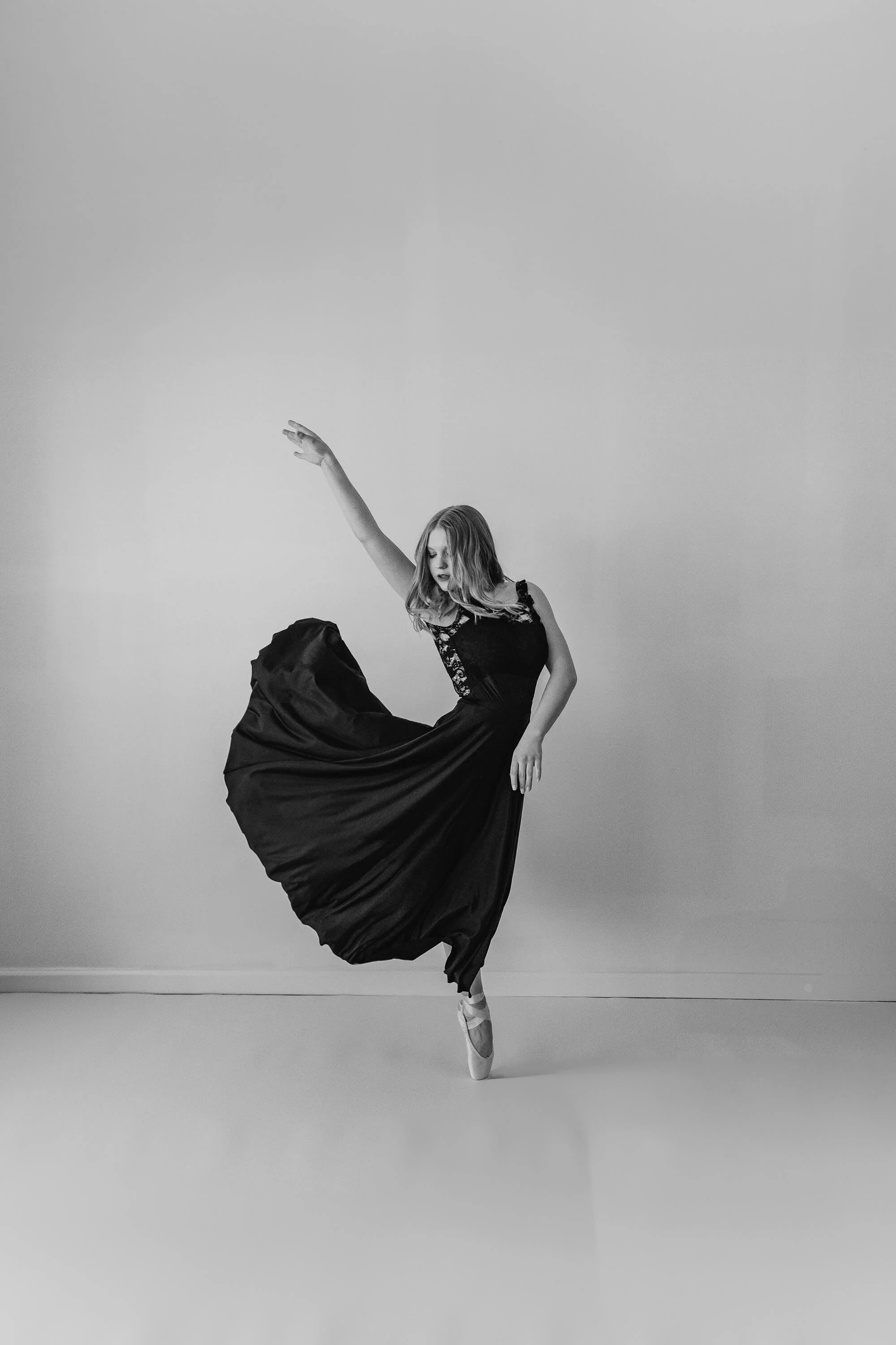 A black and white image of a senior in Bloomington, IL dances with ease during her creative dance session.