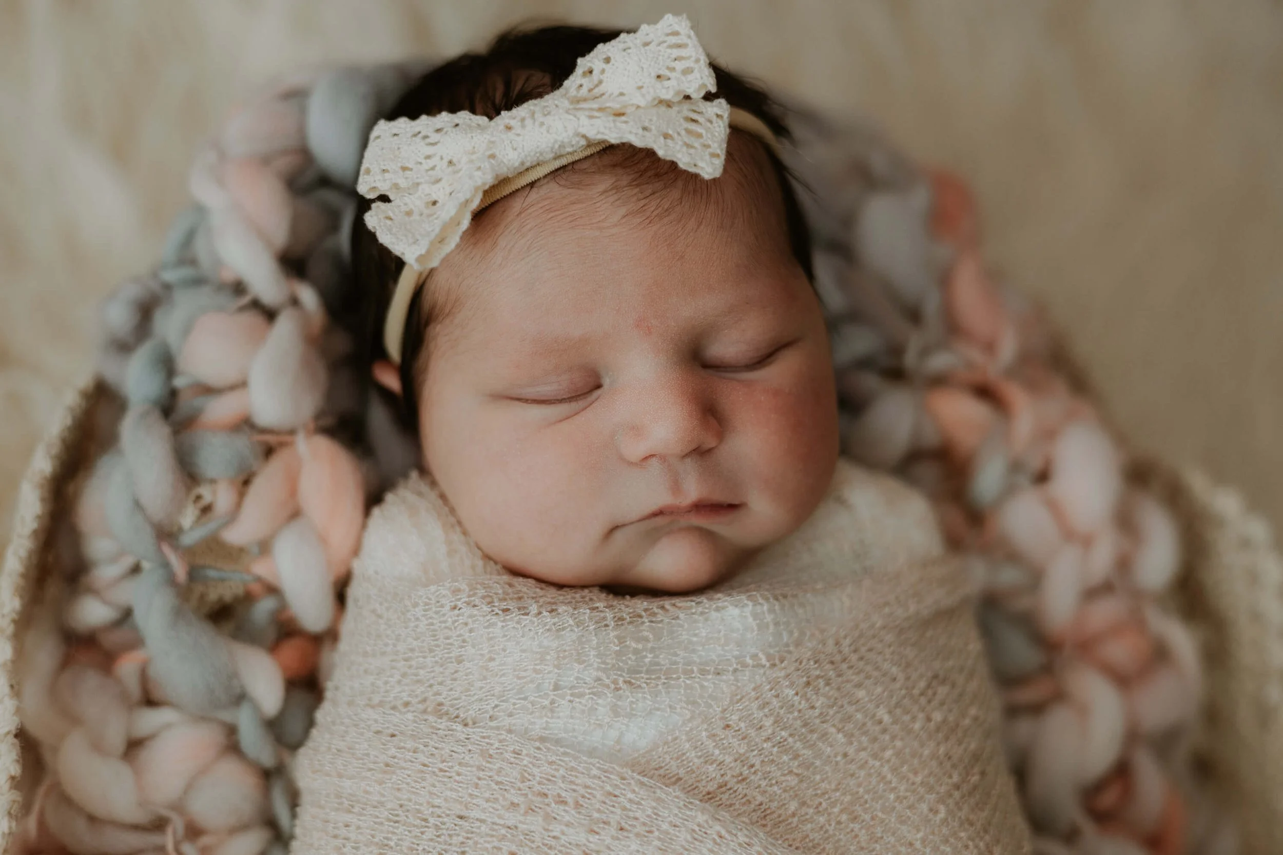 A newborn girl is swaddled in a soft clothwrap