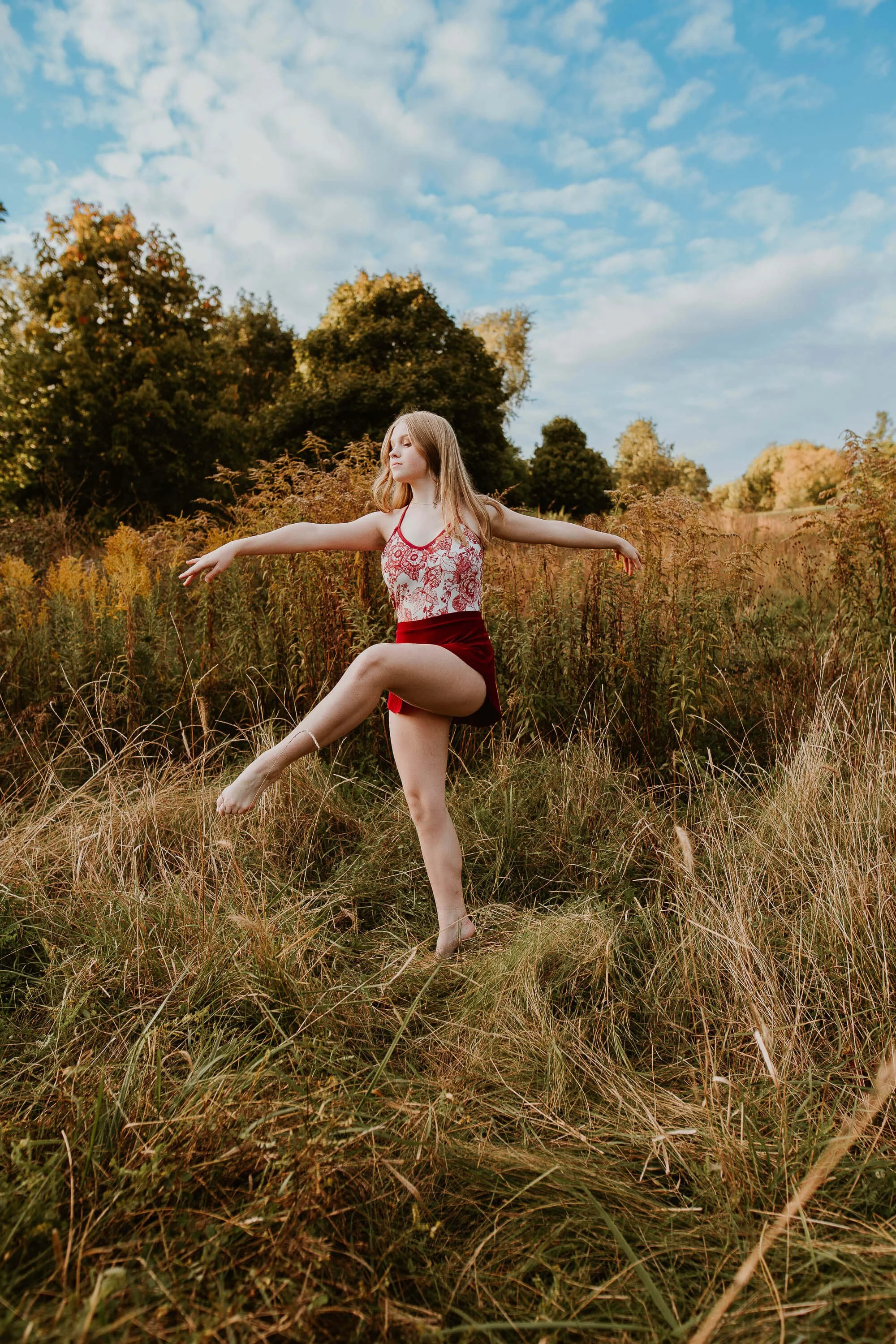 Prairie grass surrounds ballet dancer Katy as she balances on one leg.