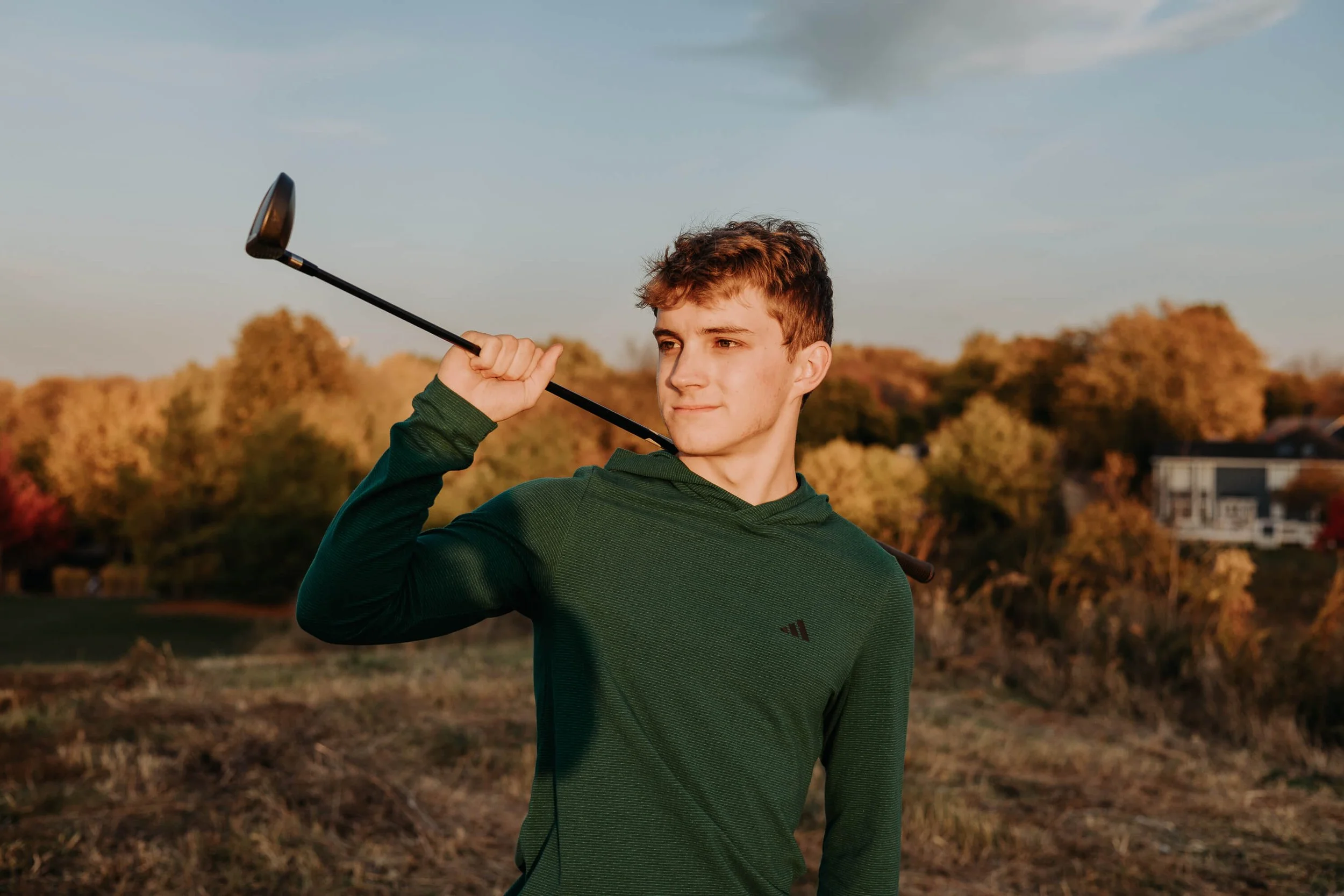 A close up of a teenage golfer.