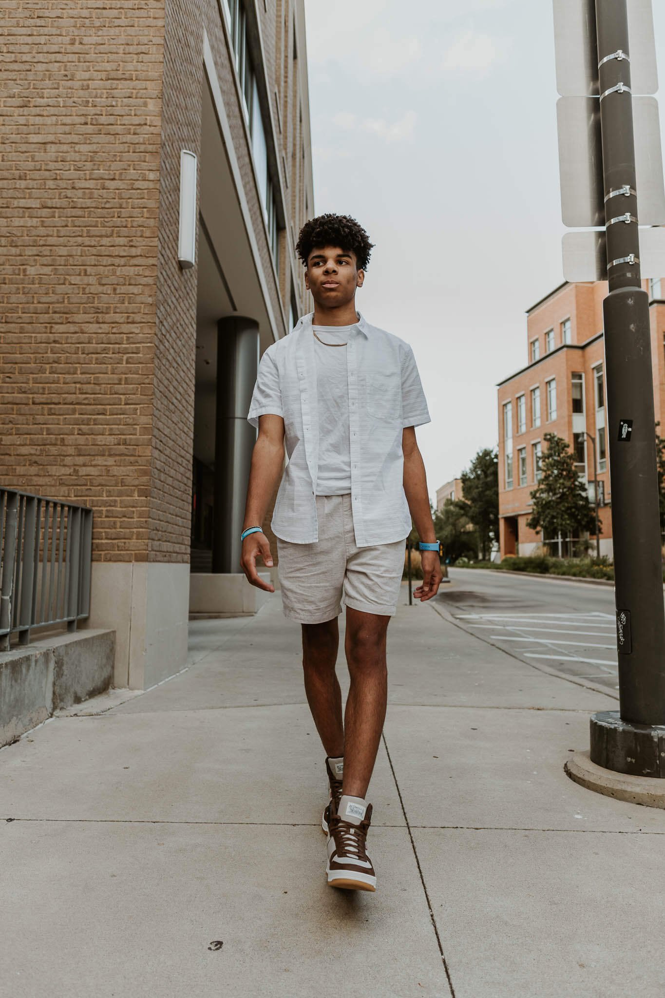 A senior boy walks confidently on the sidewalk just outside of Hacienda Leon in Normal IL.