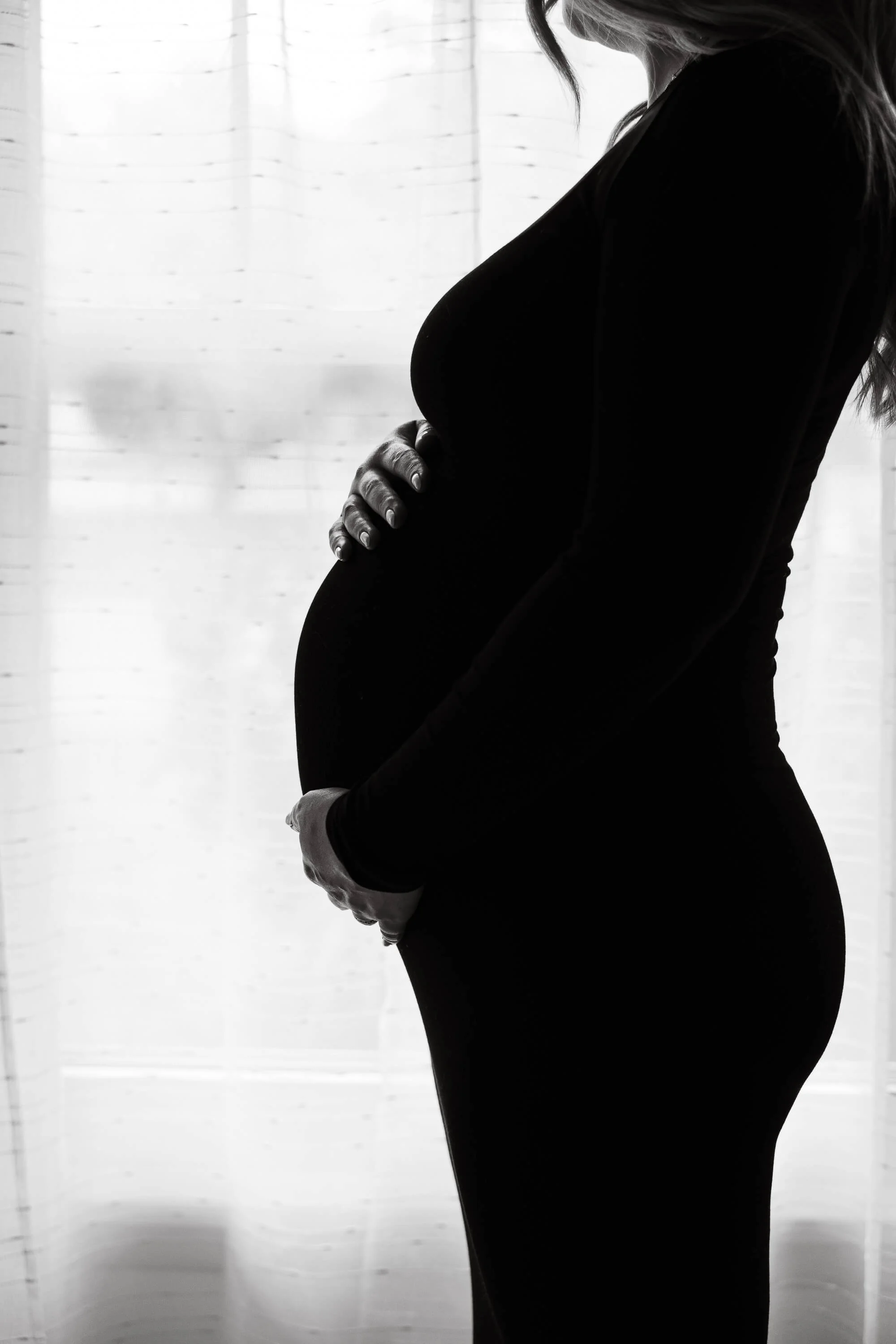 A close up sillhouette of a pregnant belly