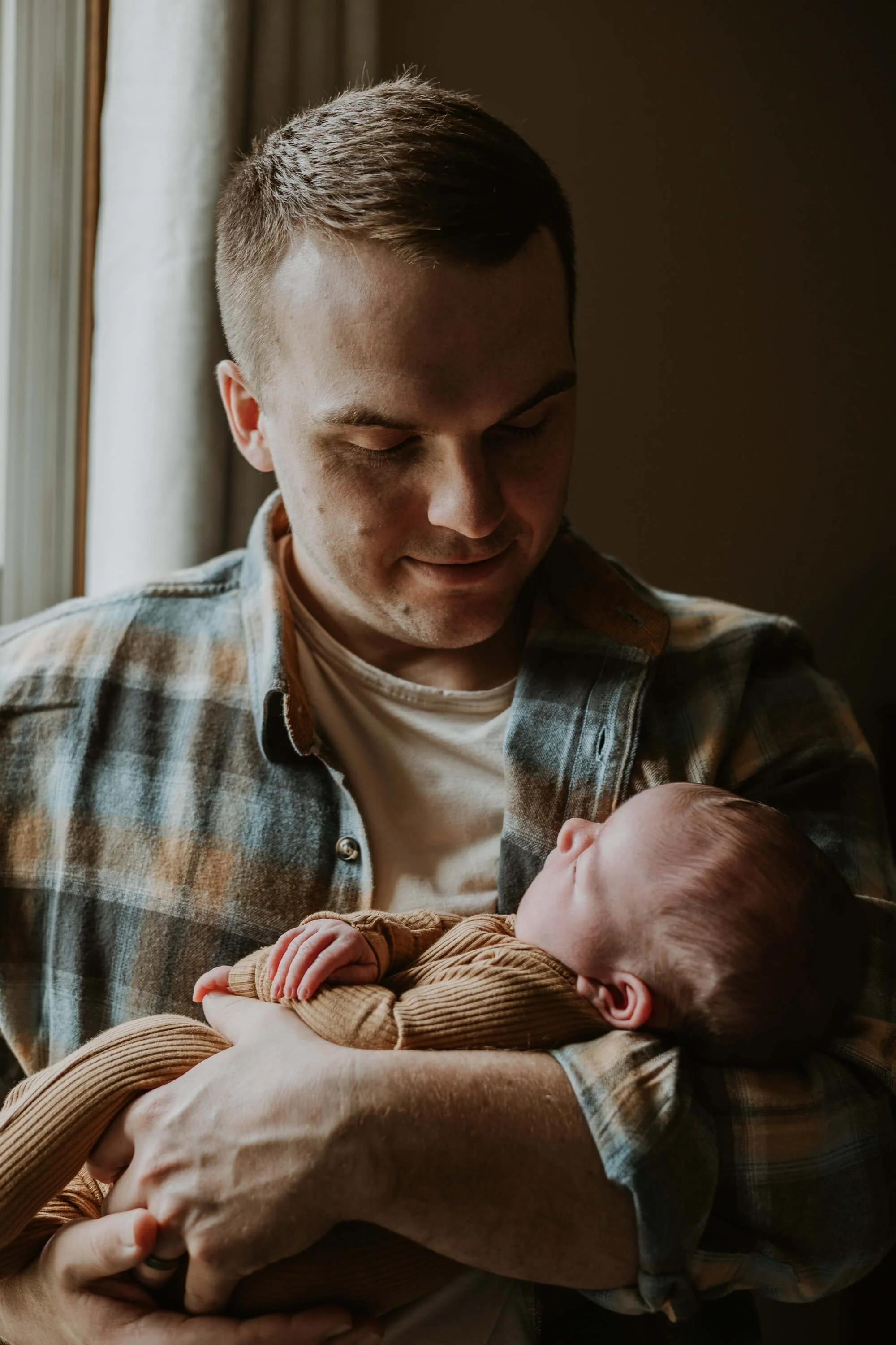 A father proudly holds his newborn son