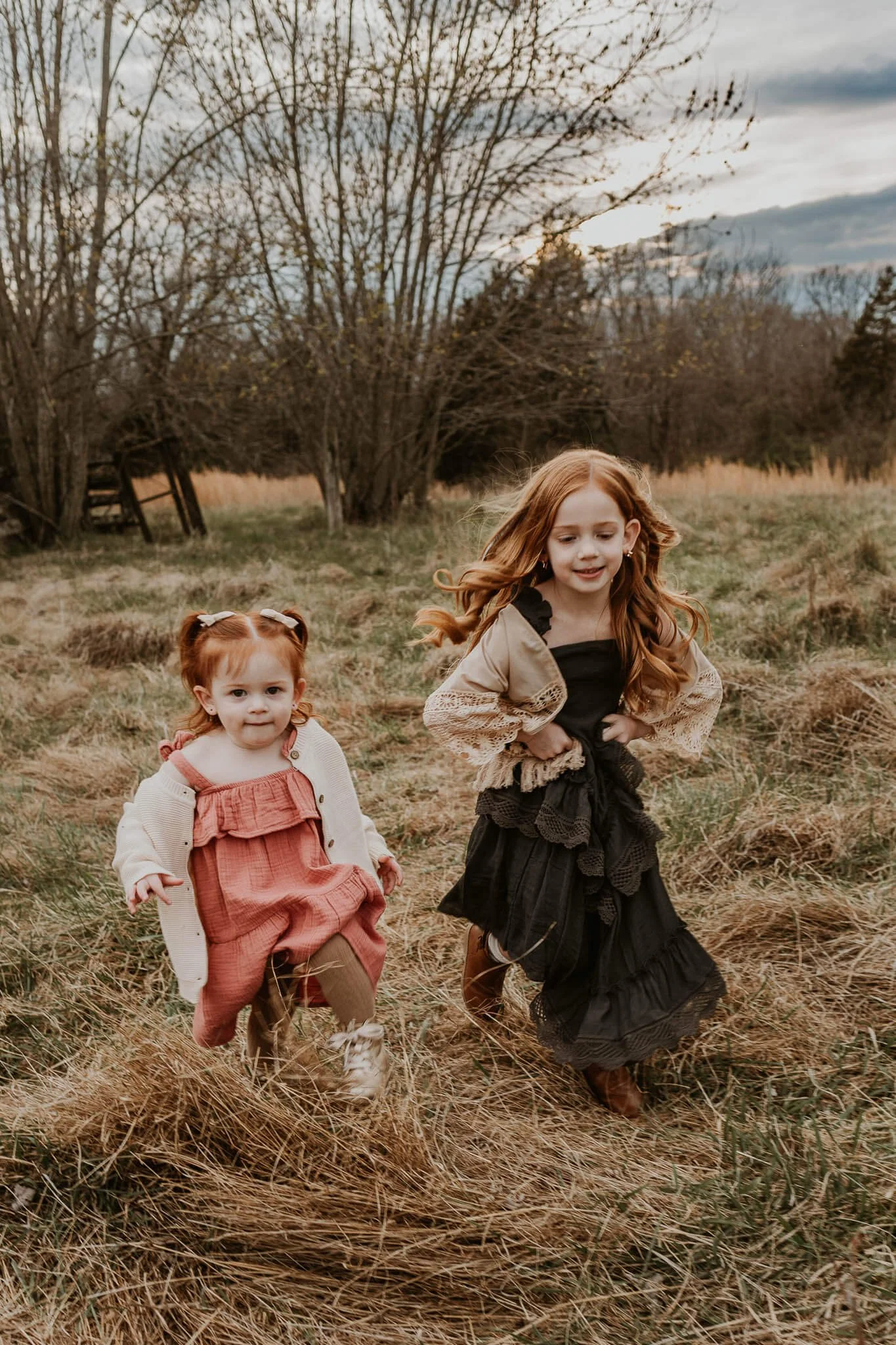 two red-headed sisters running through a field