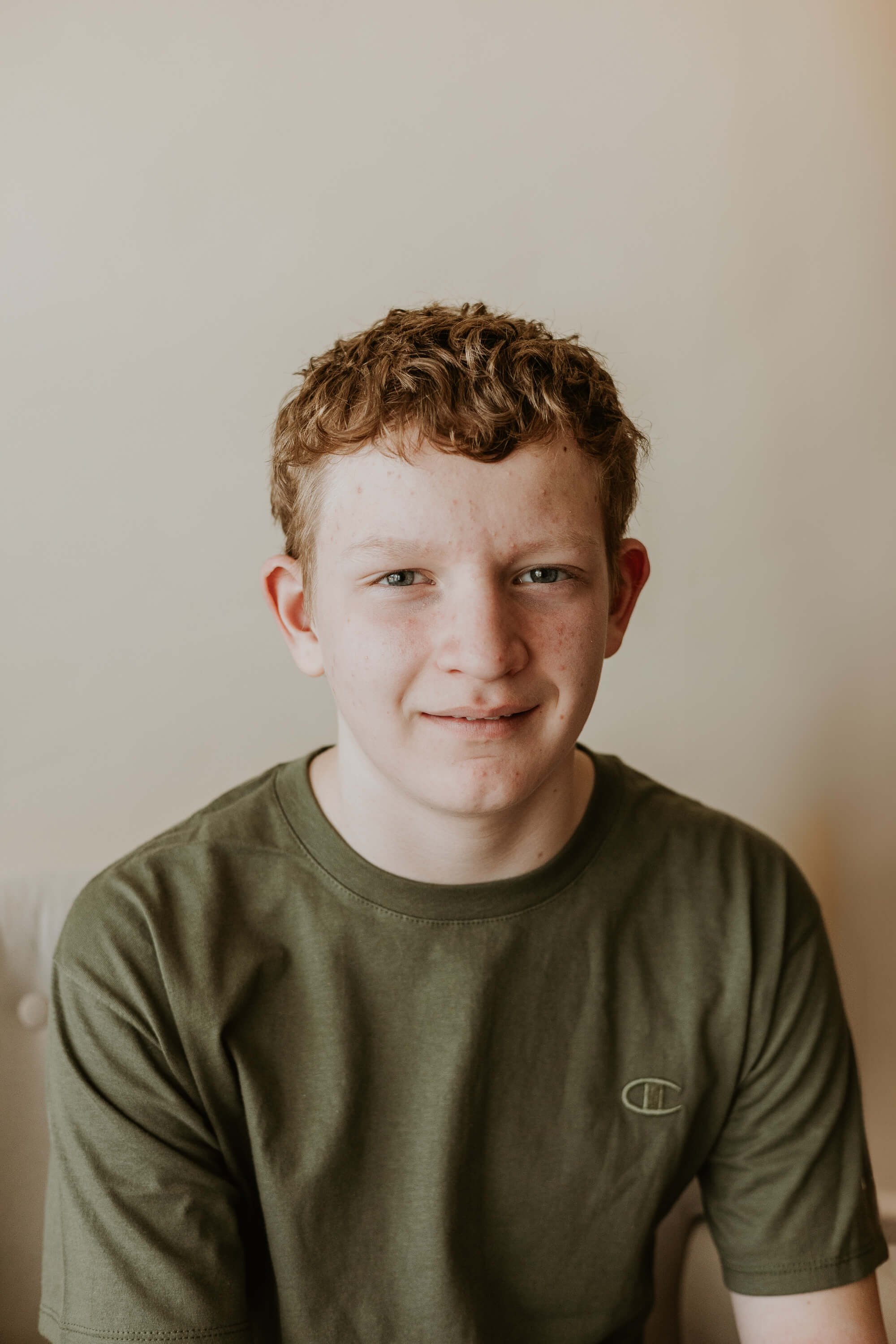 A thirteen year old boy smiles softly