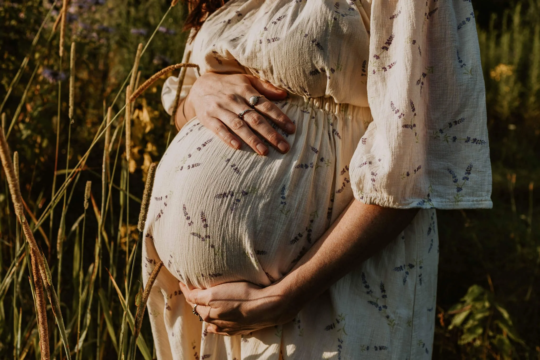 A pregnant belly cradled by a woman's hands