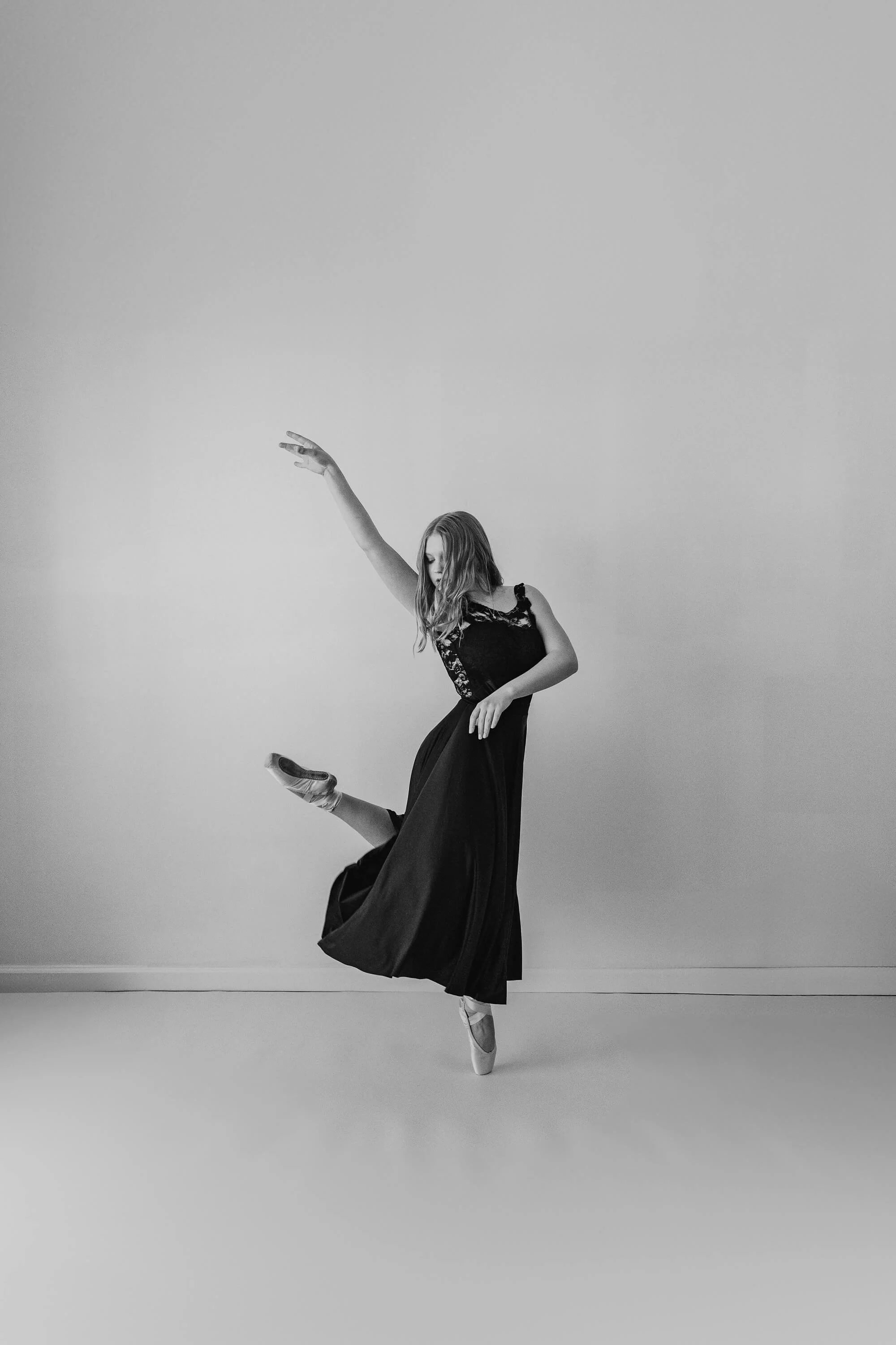A black and white image of a high school dancer holding a pose en pointe.