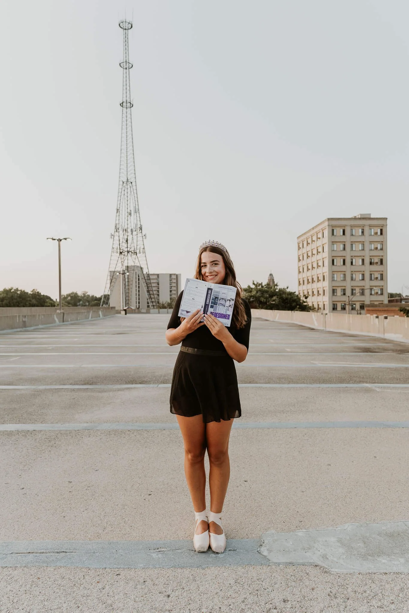 A teen smiles coyly while holding her favorite book just under her chin