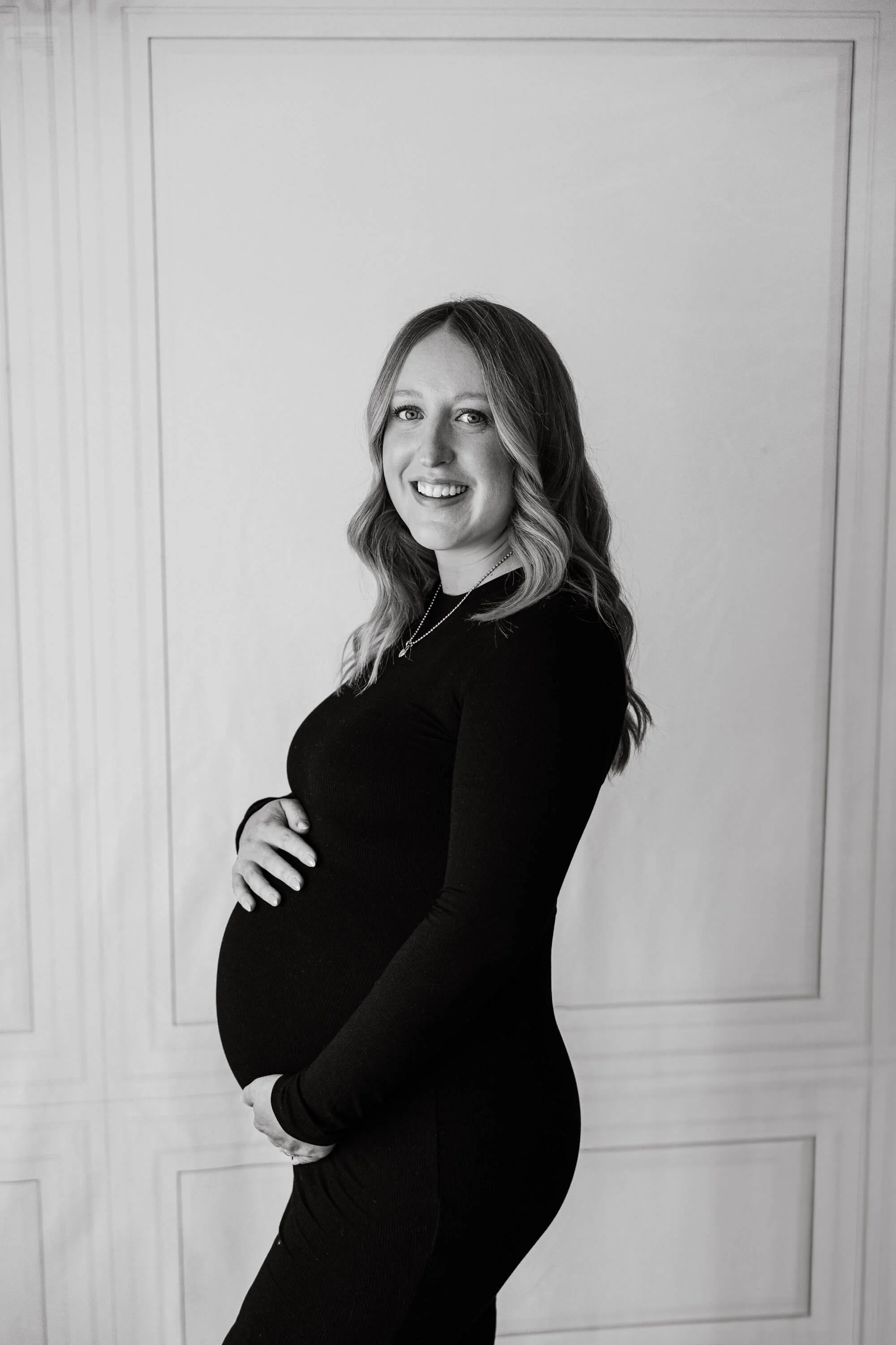 a pregnant woman poses holding her belly