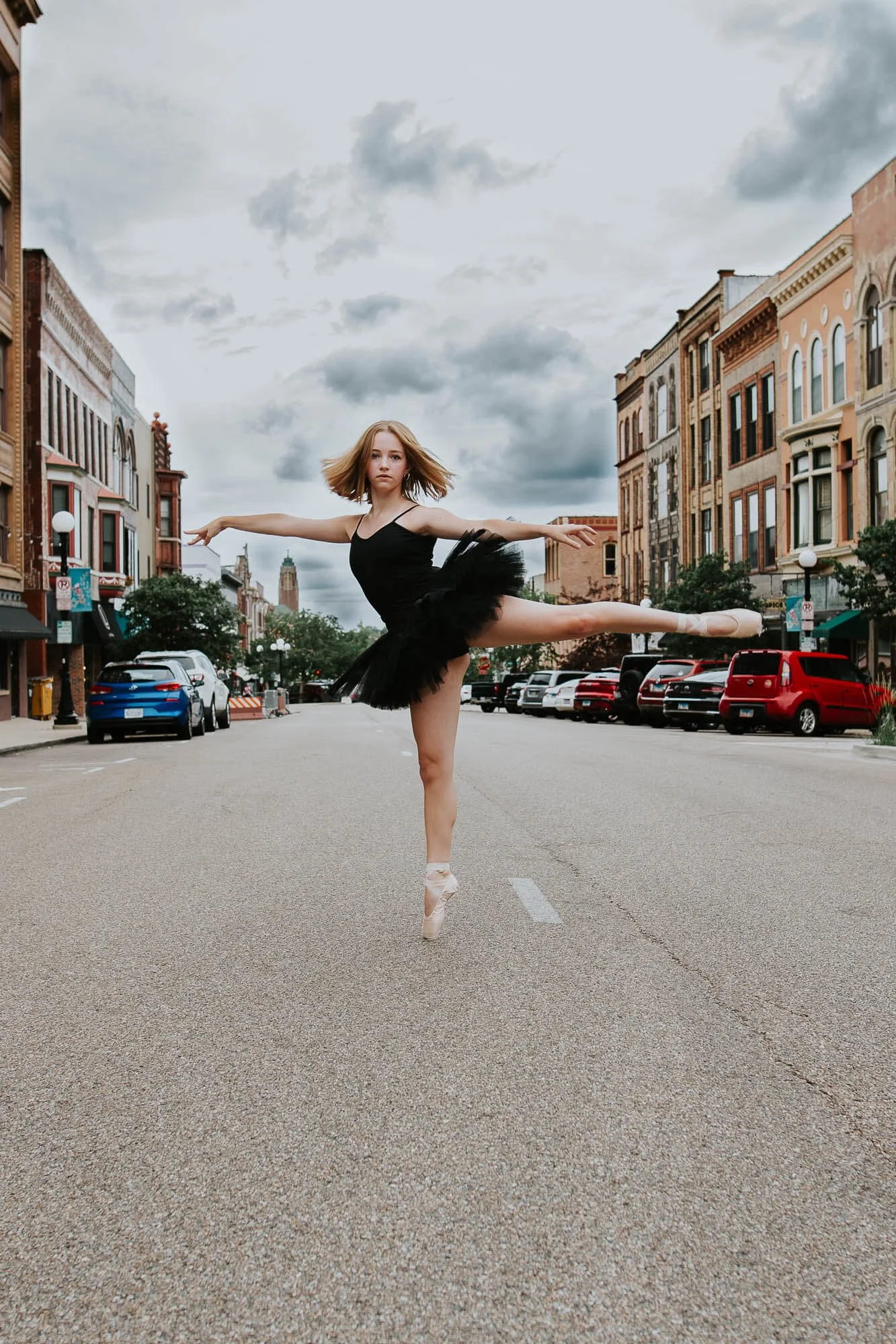 A teen dancer holds a pose en pointe in the middle of Main Street in Downtown Bloomington IL