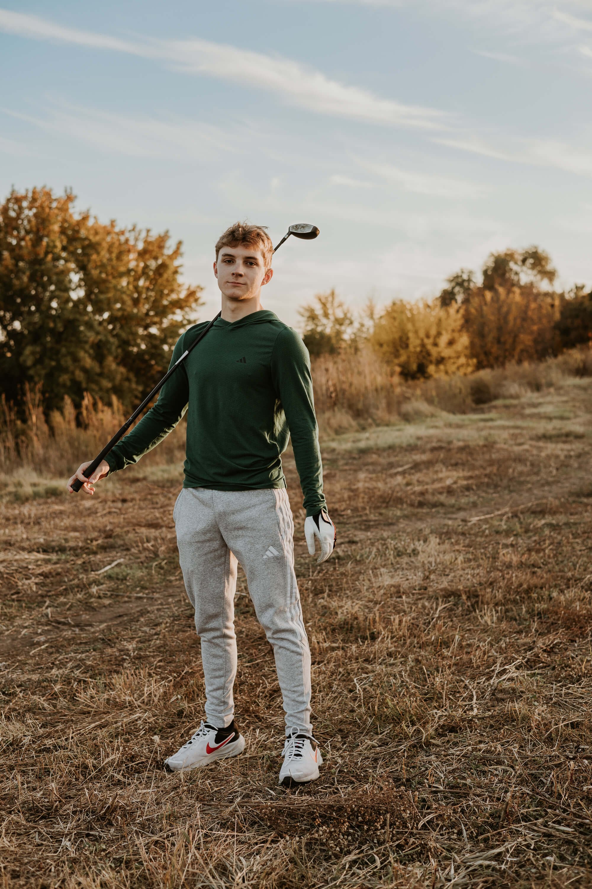 A teen boy holds his golf club atop the hill on Jersey Avenue in Normal IL
