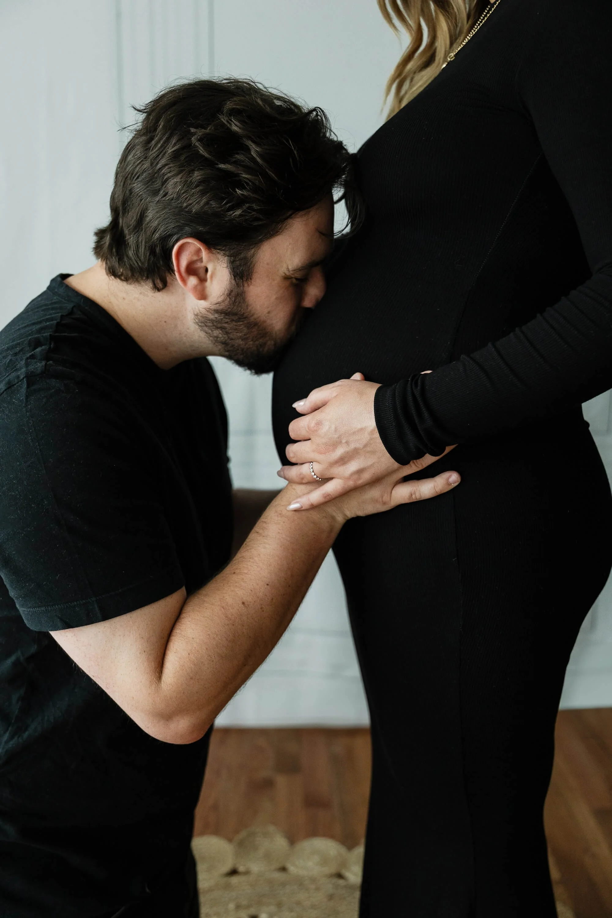 A father-to-be kisses his wife's pregnant belly