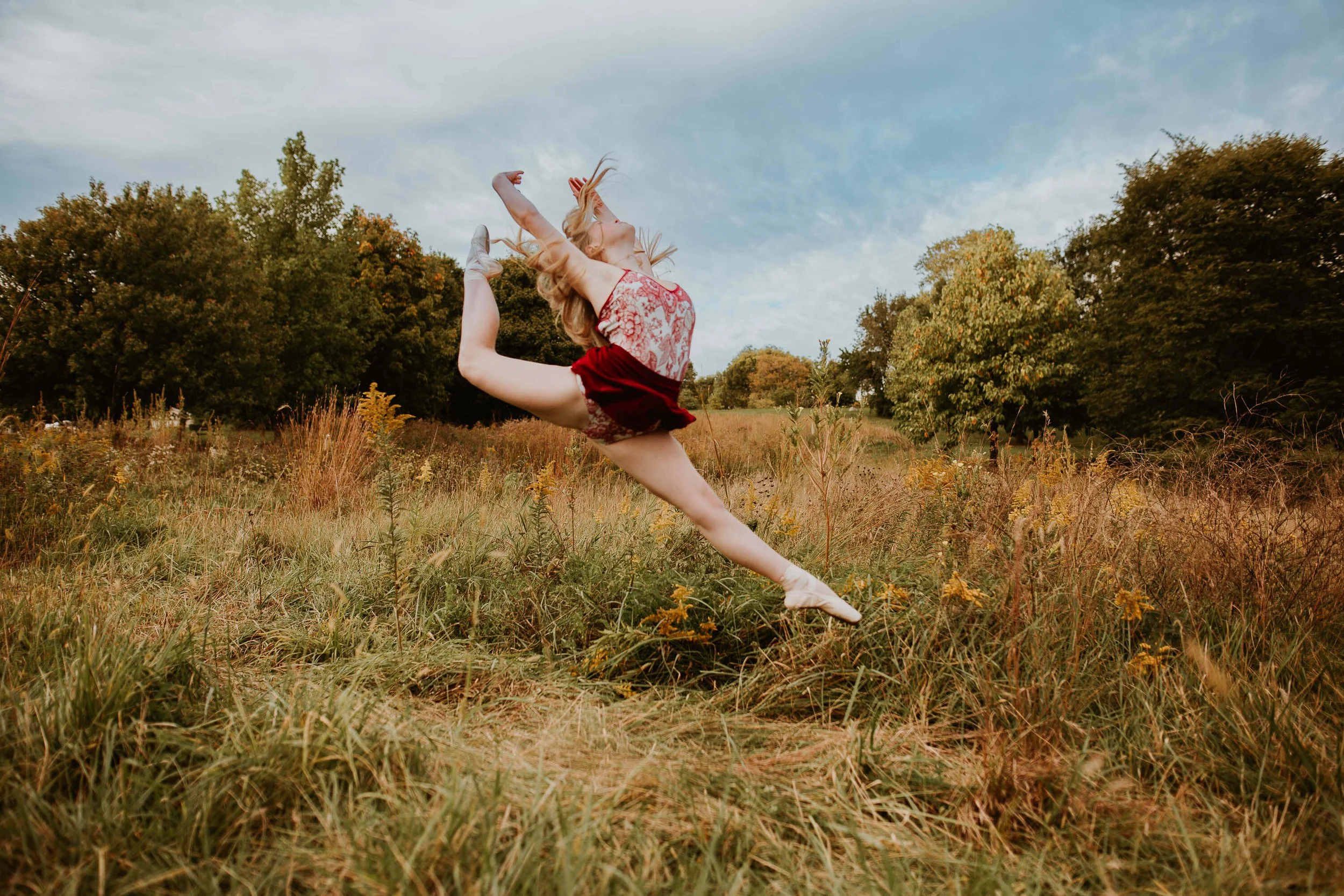 A tall leap in the air, a teen ballerina shows off her ability to jump gracefully 