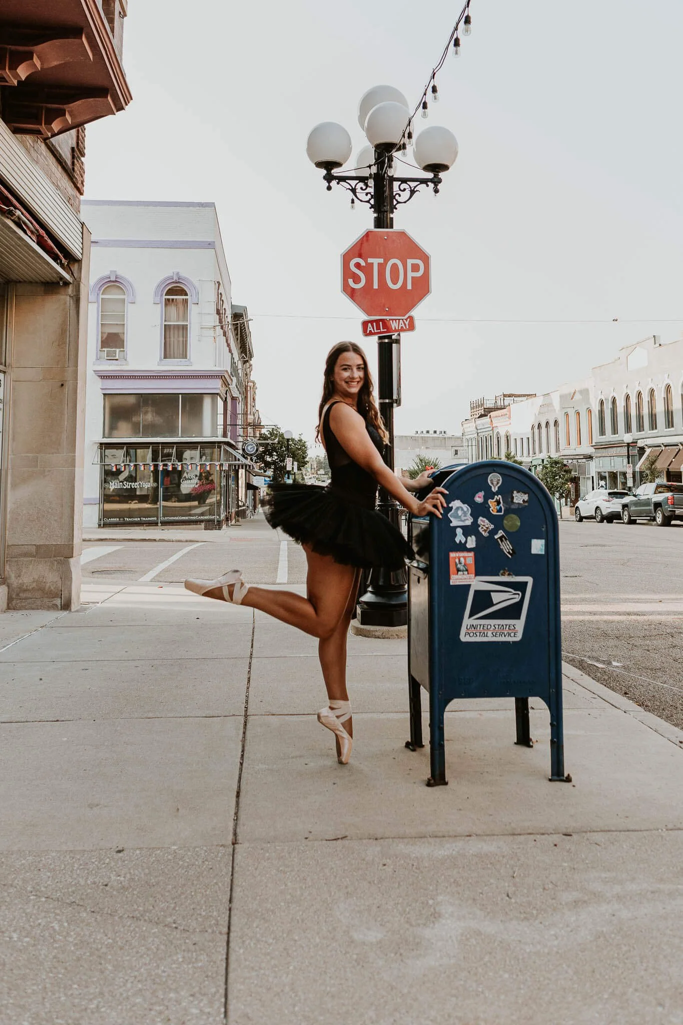 Showing her strength and skill, a dancer stands en pointe at a mailbox 