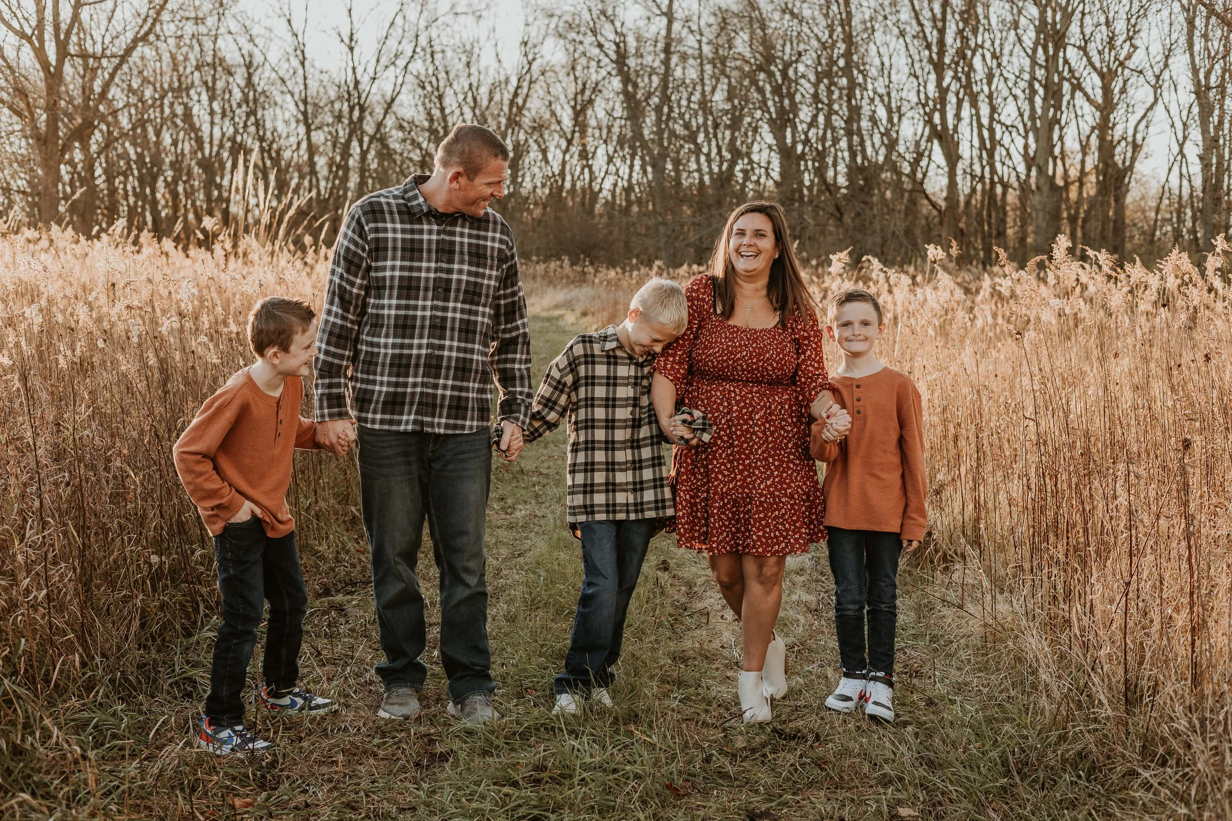 Twins and their older brother bump playfully into their parents during their family photography session