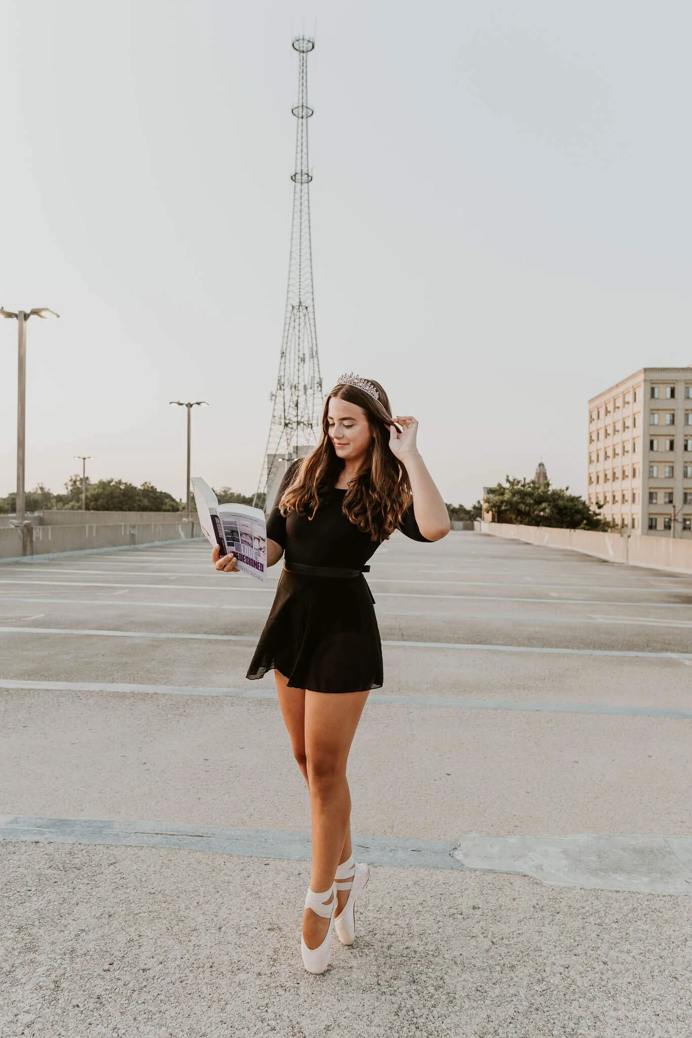 Wearing a tiarra and holding her favorite book, a teen dancer makes standing en pointe look easy