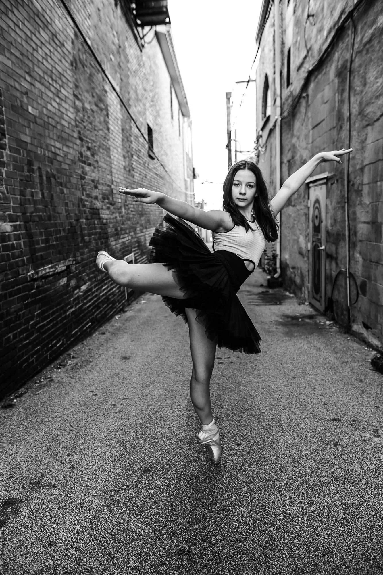 A ballerina holds a graceful pose in an alley in Downtown Bloomington, IL