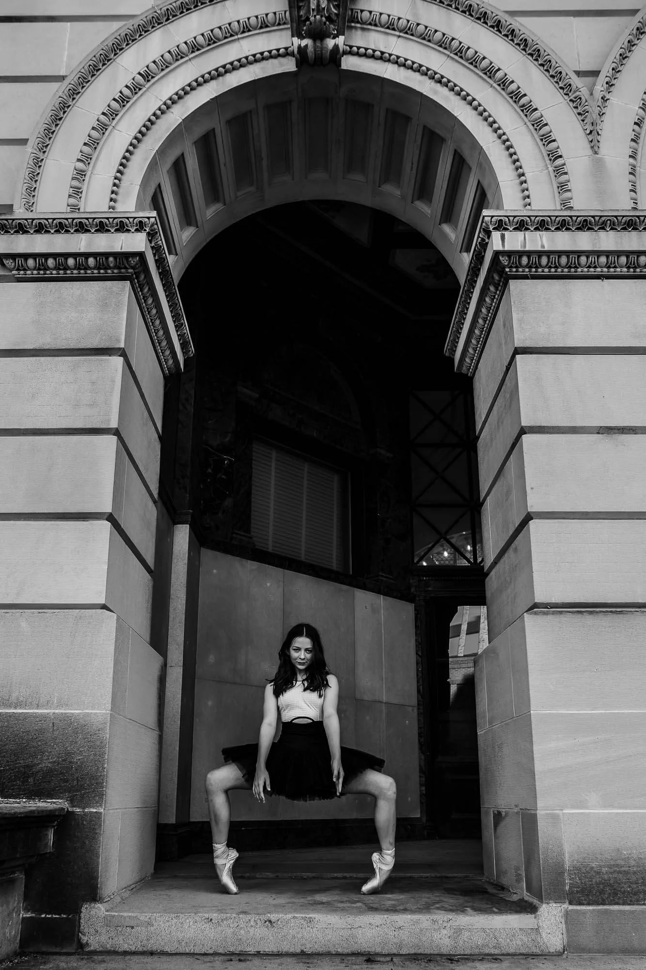 A black and white image of a dancer holding second position en pointe.