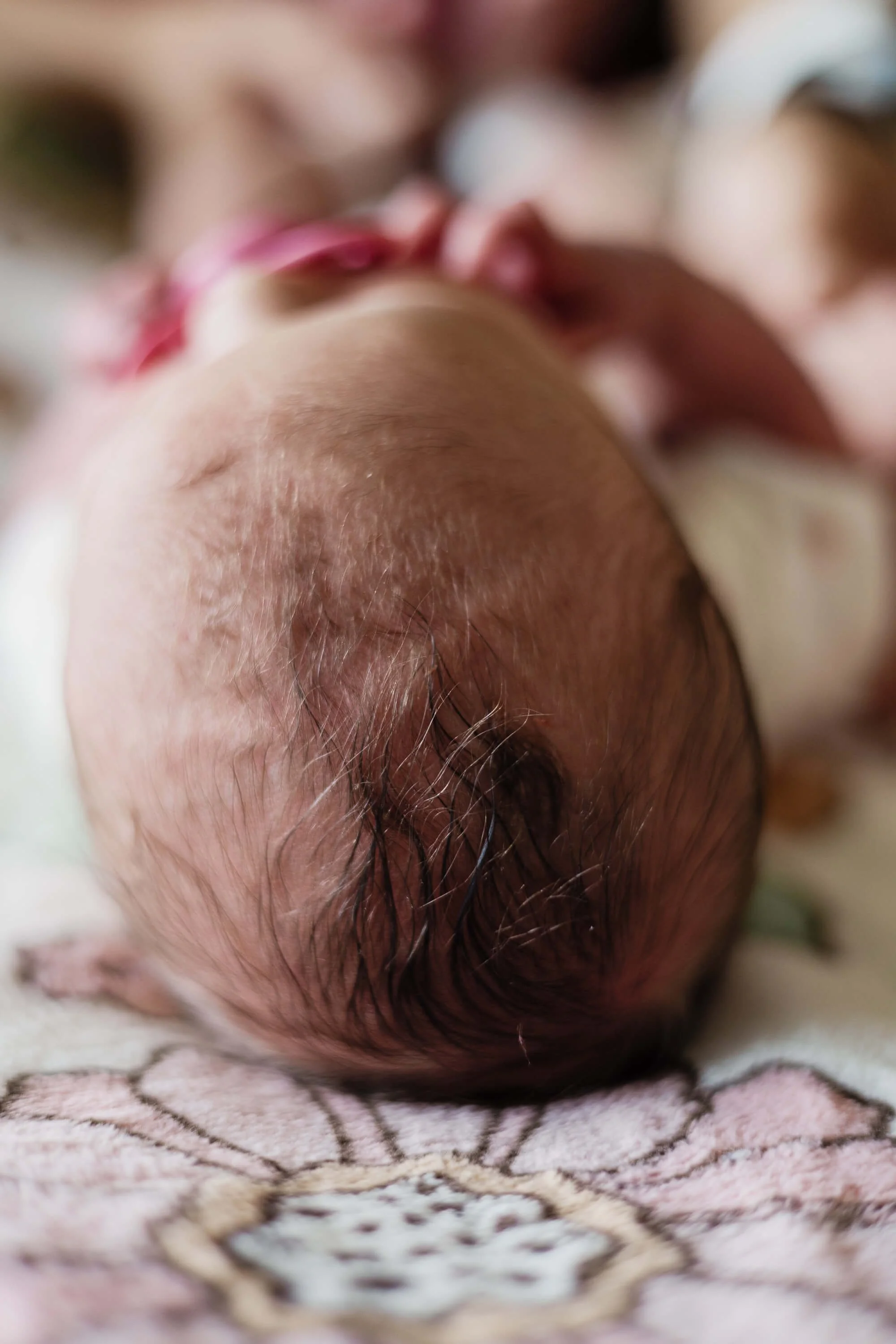 The top of a newborn's head showing a fair amount of dark hair