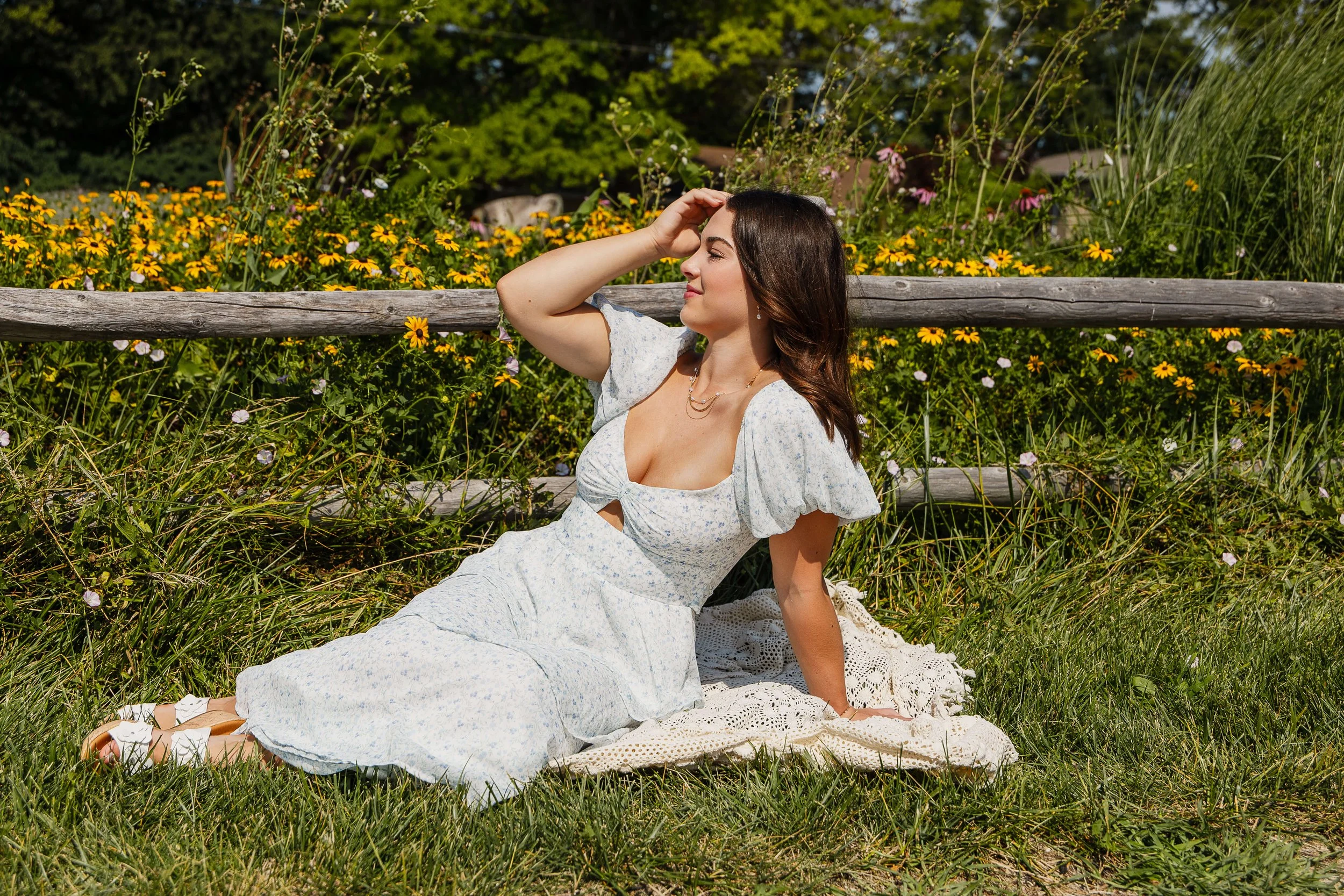 Juliette, class of 2027, wears a long white flowy dress for her floral session in Normal, IL