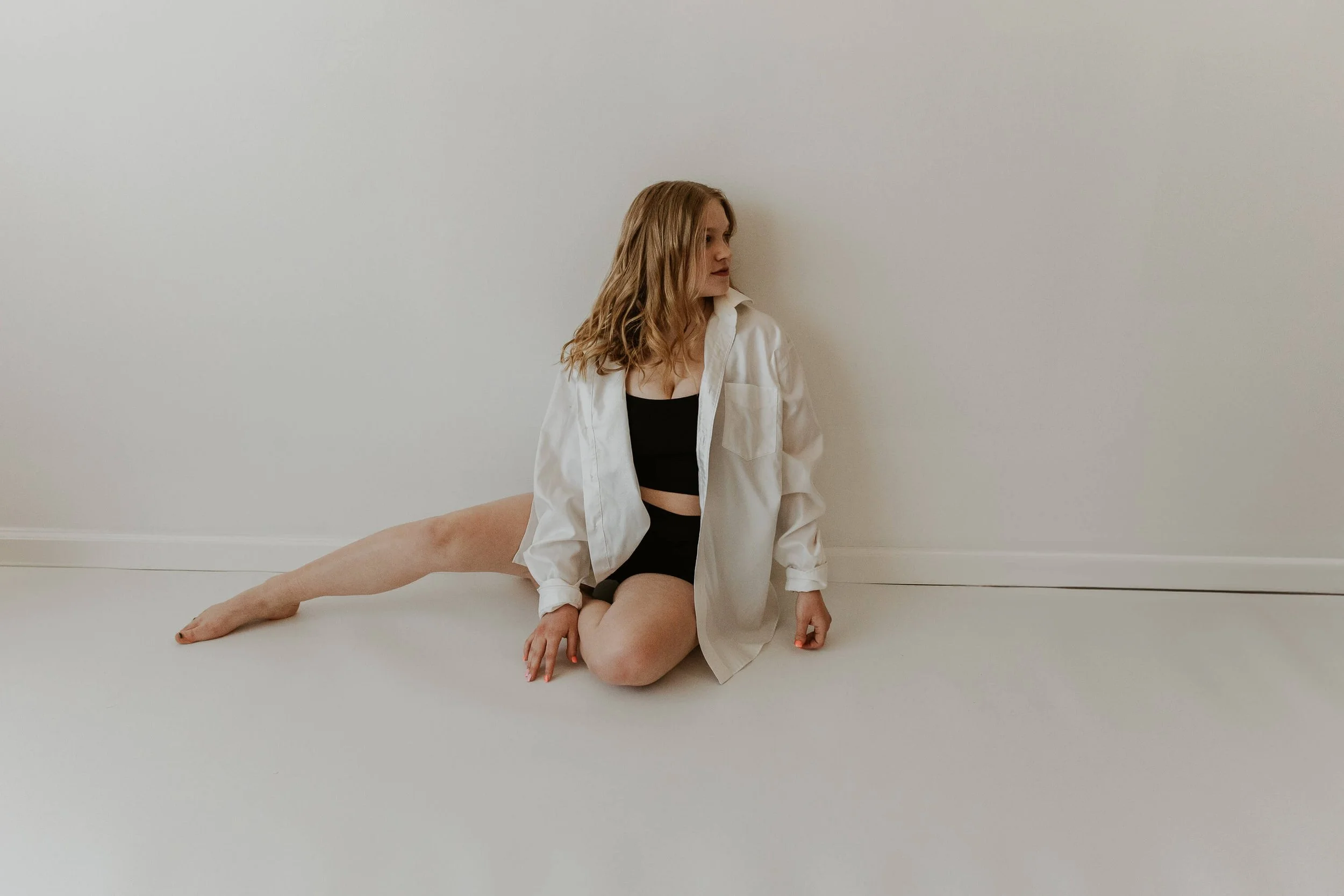 A dancer looks casually off to the side during a break from warm ups.