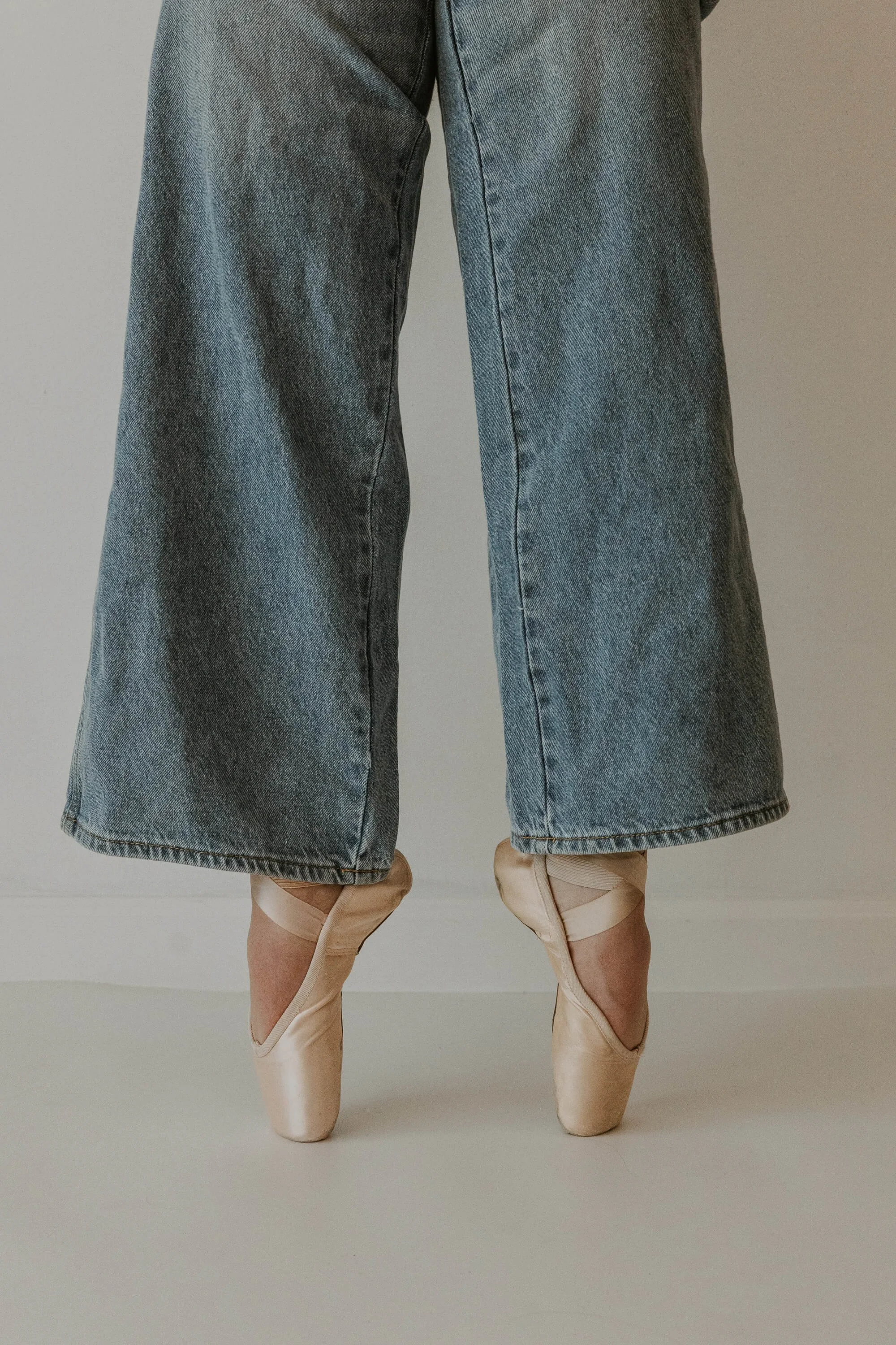 Flare jeans and pointe shoes in first position.