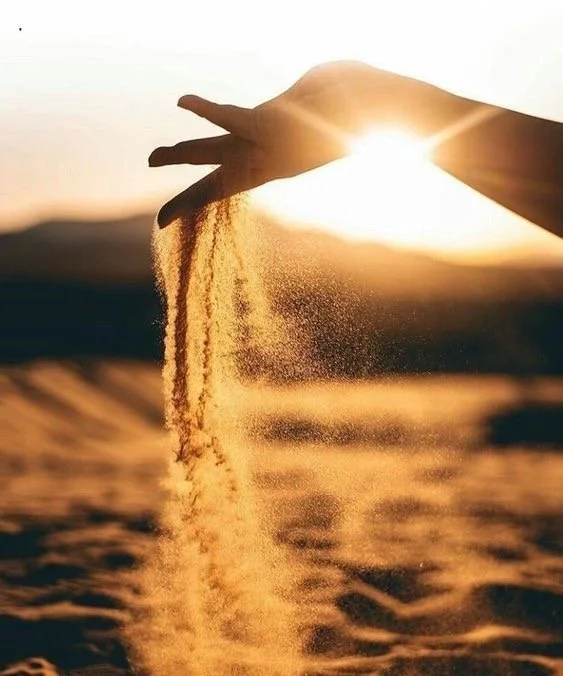 A hand releasing golden sand into glowing sunlight, symbolising prophetic discernment, spiritual separation, and the shift into a new era of calling.