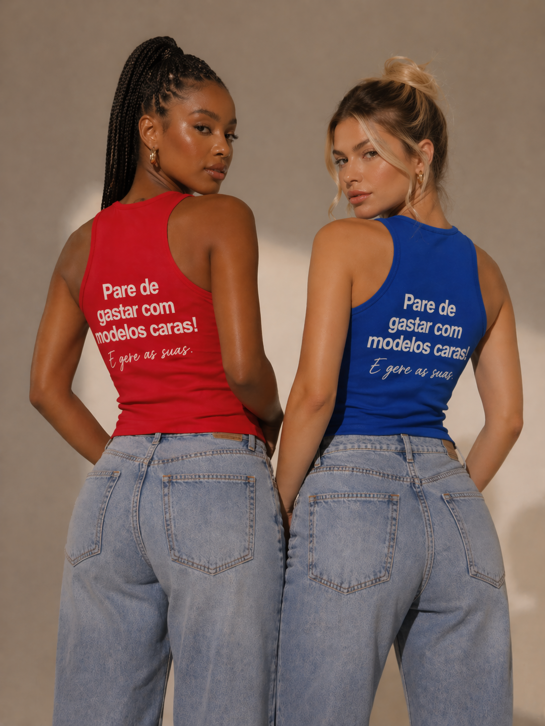 Duas mulheres usando camisetas sem mangas, uma vermelha e outra azul, com frases em português. Ambas estão de costas, olhando por cima do ombro, usando jeans largos.