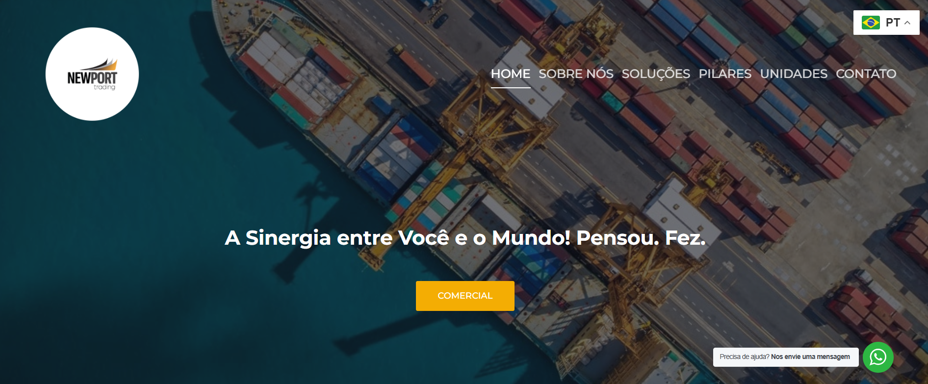 Imagem aérea de um porto com containers coloridos, berço de atracação e uma ponte de carga, sob o mar.