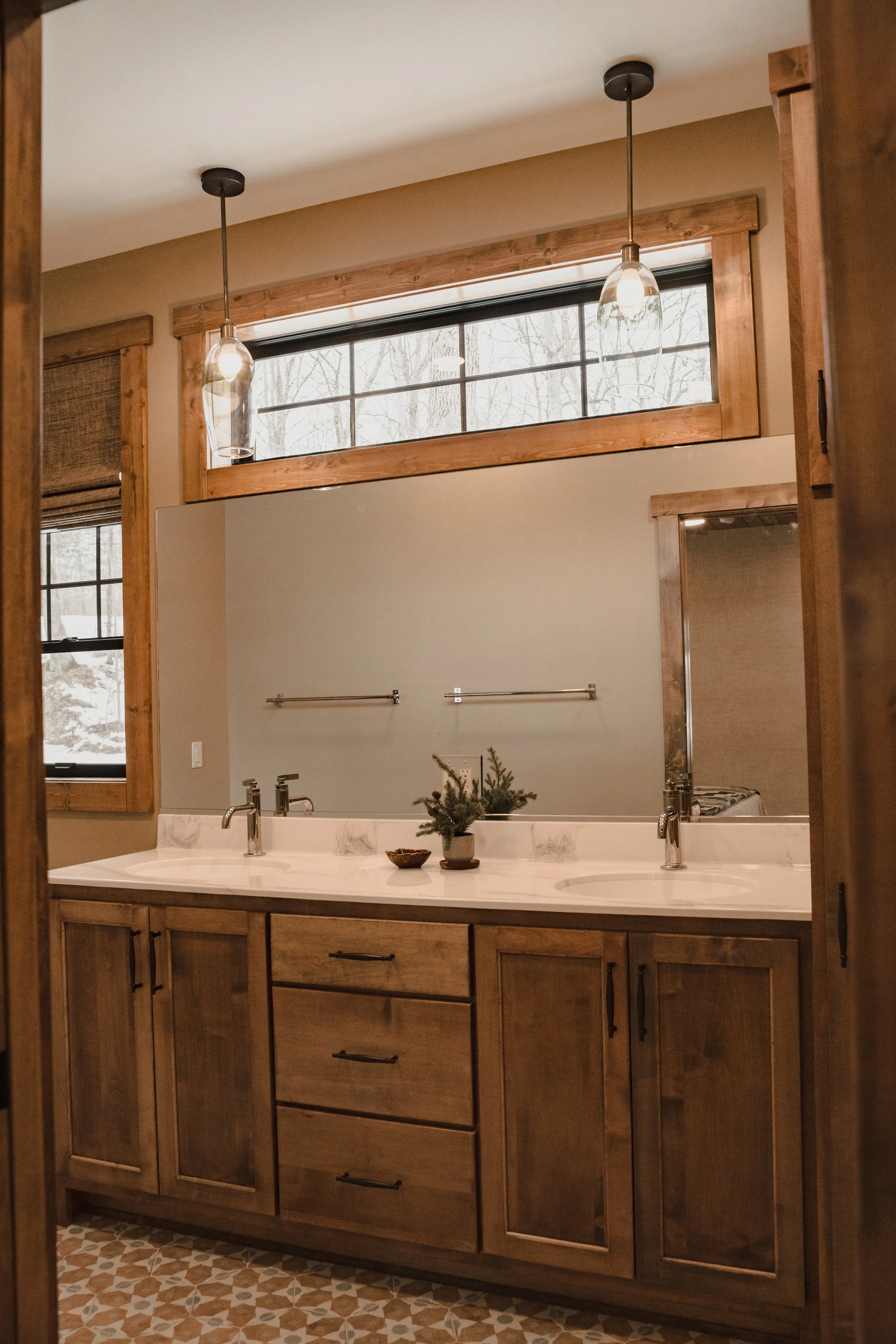 Bathroom with double vanity, custom wood cabinetry, modern fixtures and natural light.