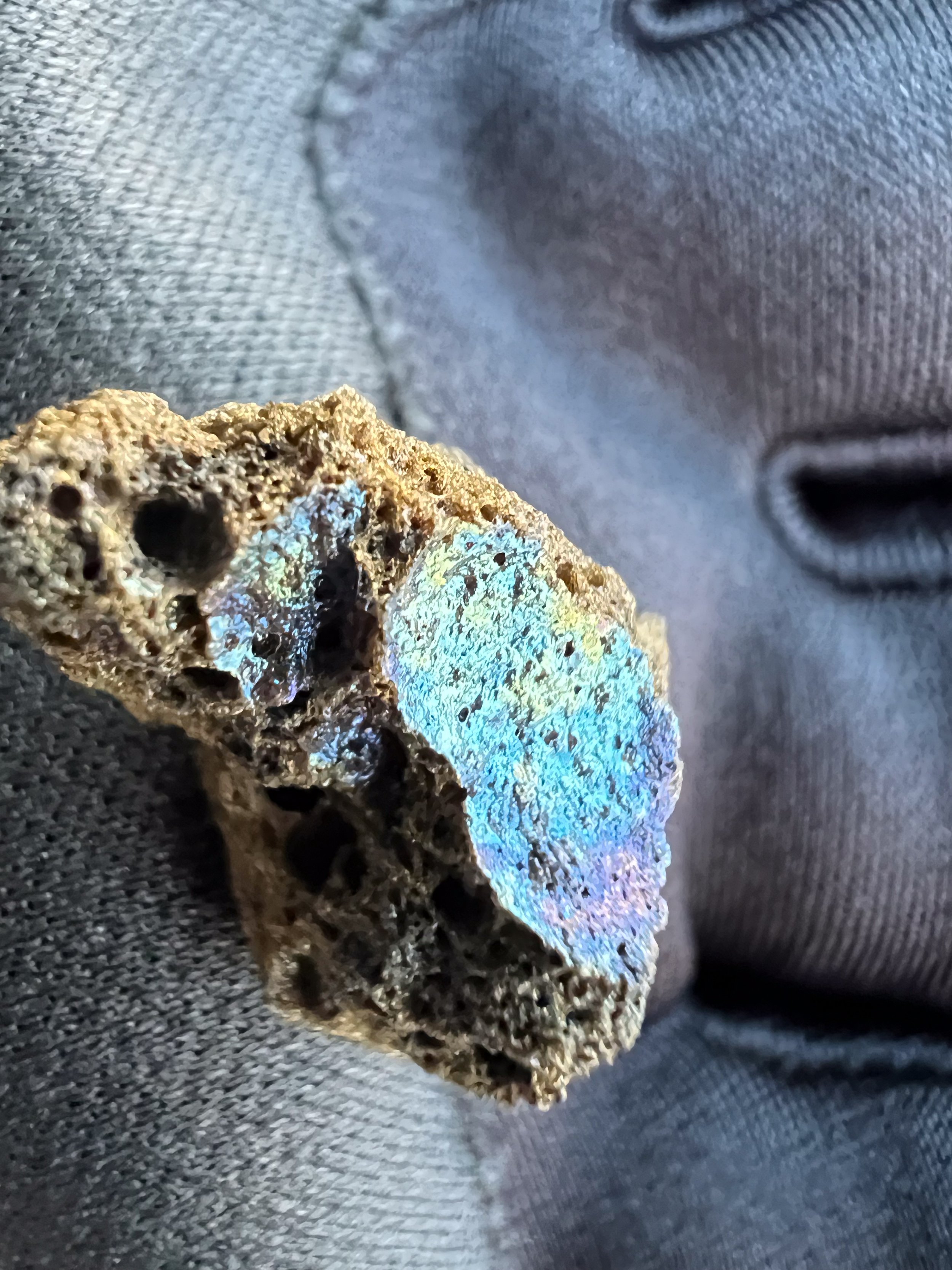 This piece of lava has a thin layer of iridescent basaltic glass. 