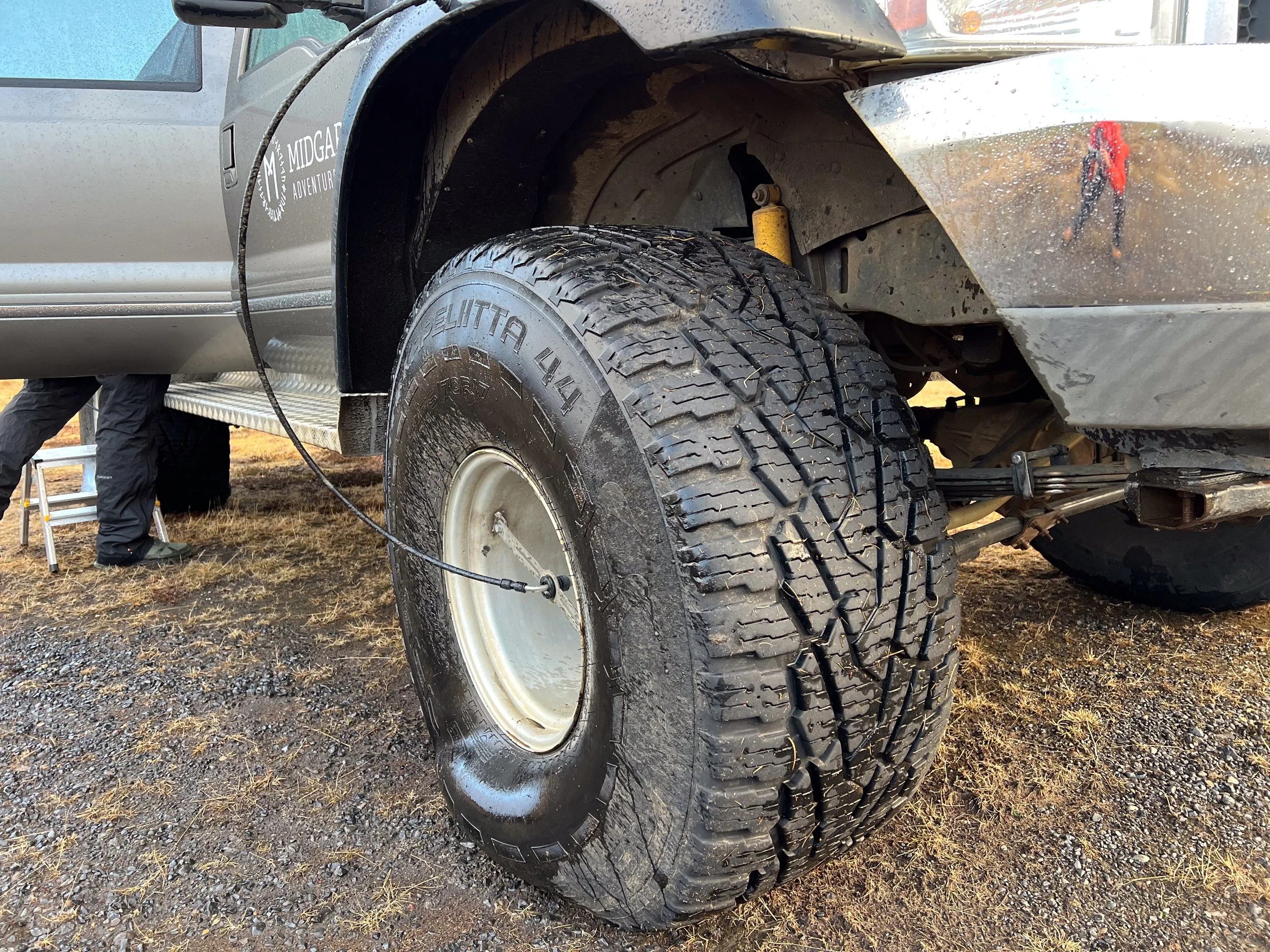 Not a flat—low tire pressure for navigating rocks and rivers. Note the tube leading from the truck's chassis to the tire. The driver can change the tire pressure from inside the cab—I  was fascinated by this system.