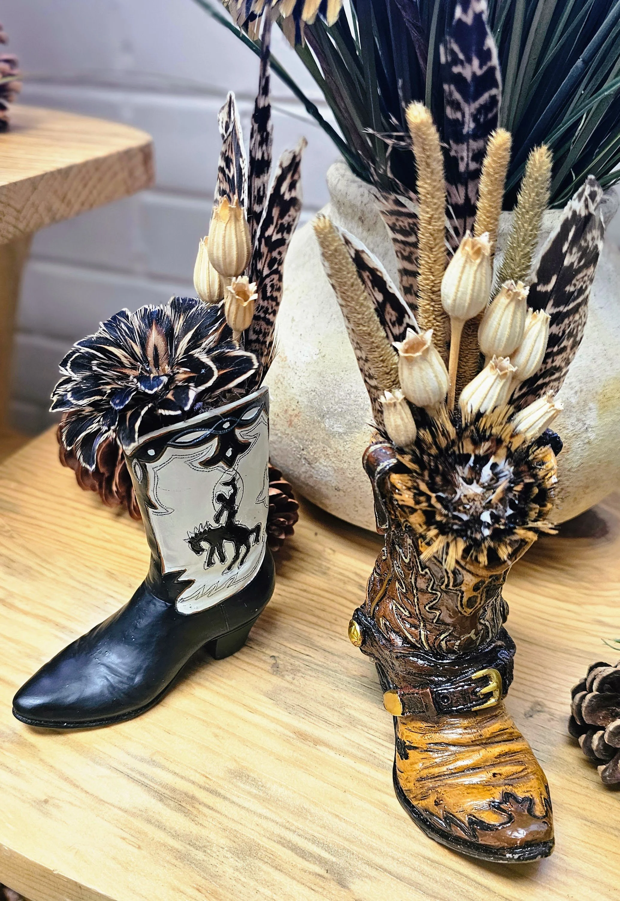 Flowers made of feathers in cowboy boot vases