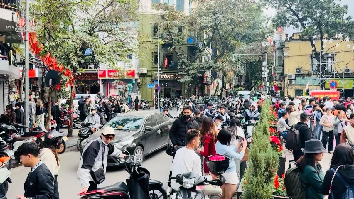 Hanoi busy traffic at Christmas time, people in the street  walking, on scooters and driving