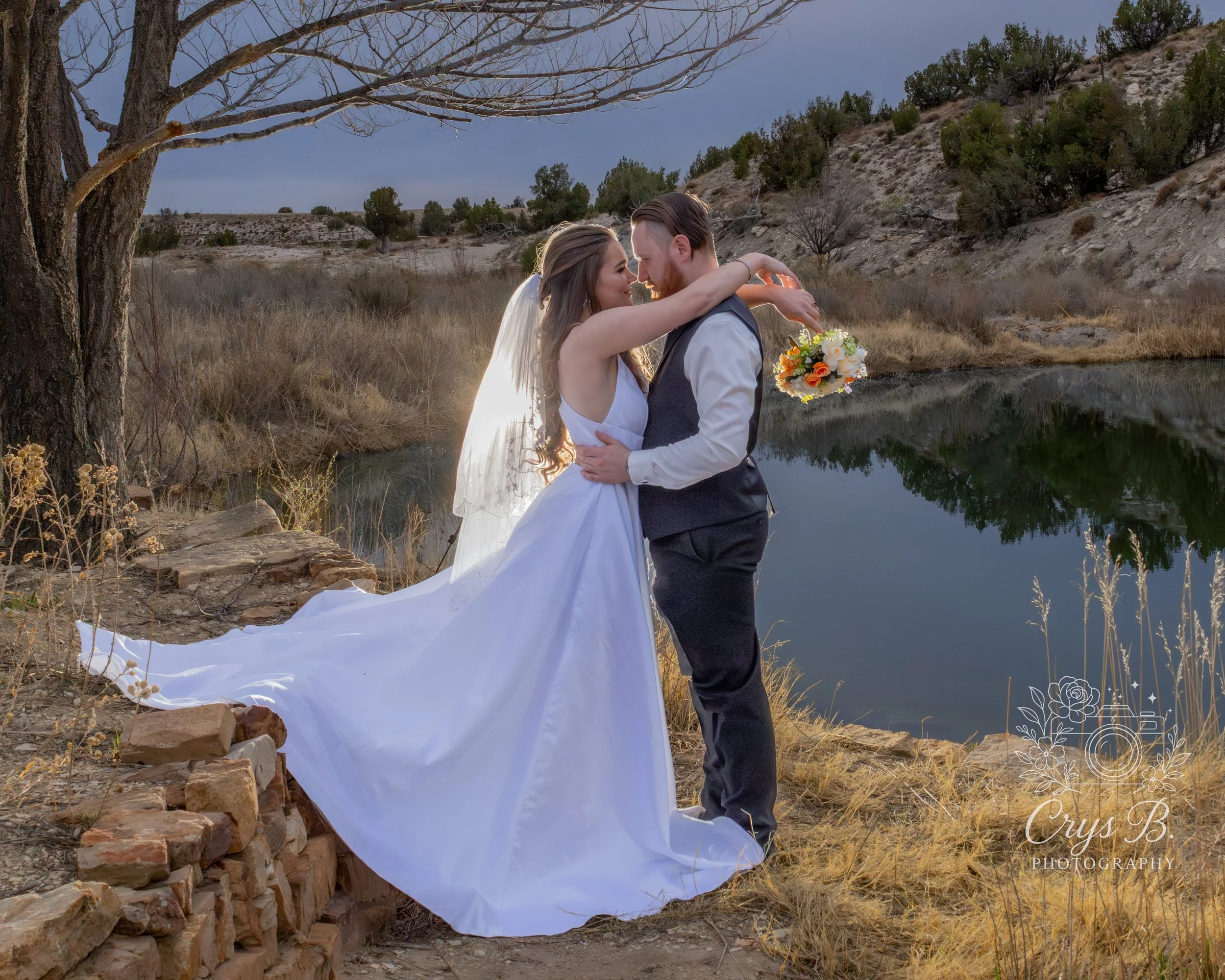 Bride and groom at pondside waterfront wedding ceremony at Lost Pond wedding venue near Pueblo, Colorado