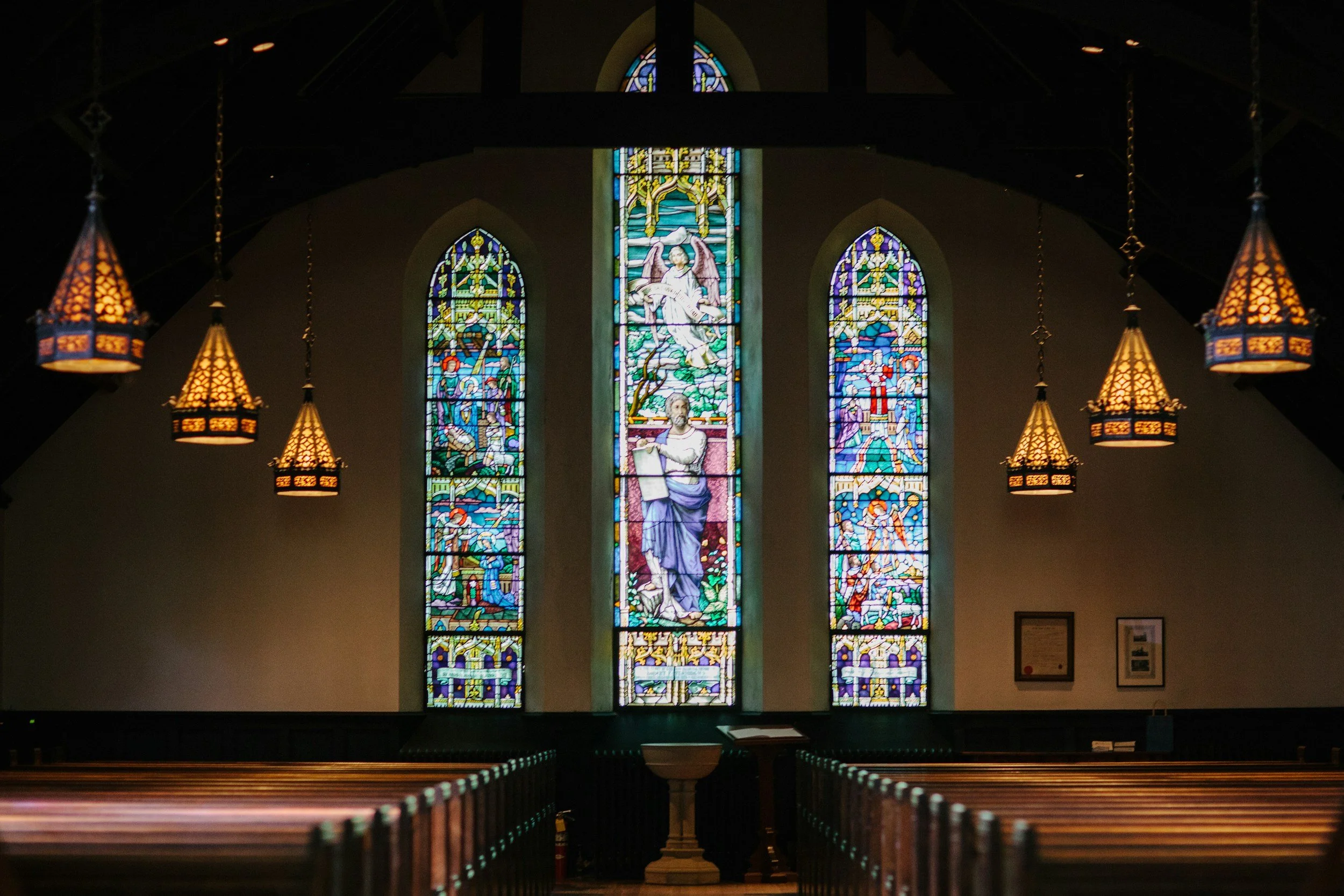 Stained glass adorns a chapel where brides and grooms can get married in a chapel or church instead of a locally owned outdoor wedding venue like Lost Pond near Colorado Springs, Colorado.