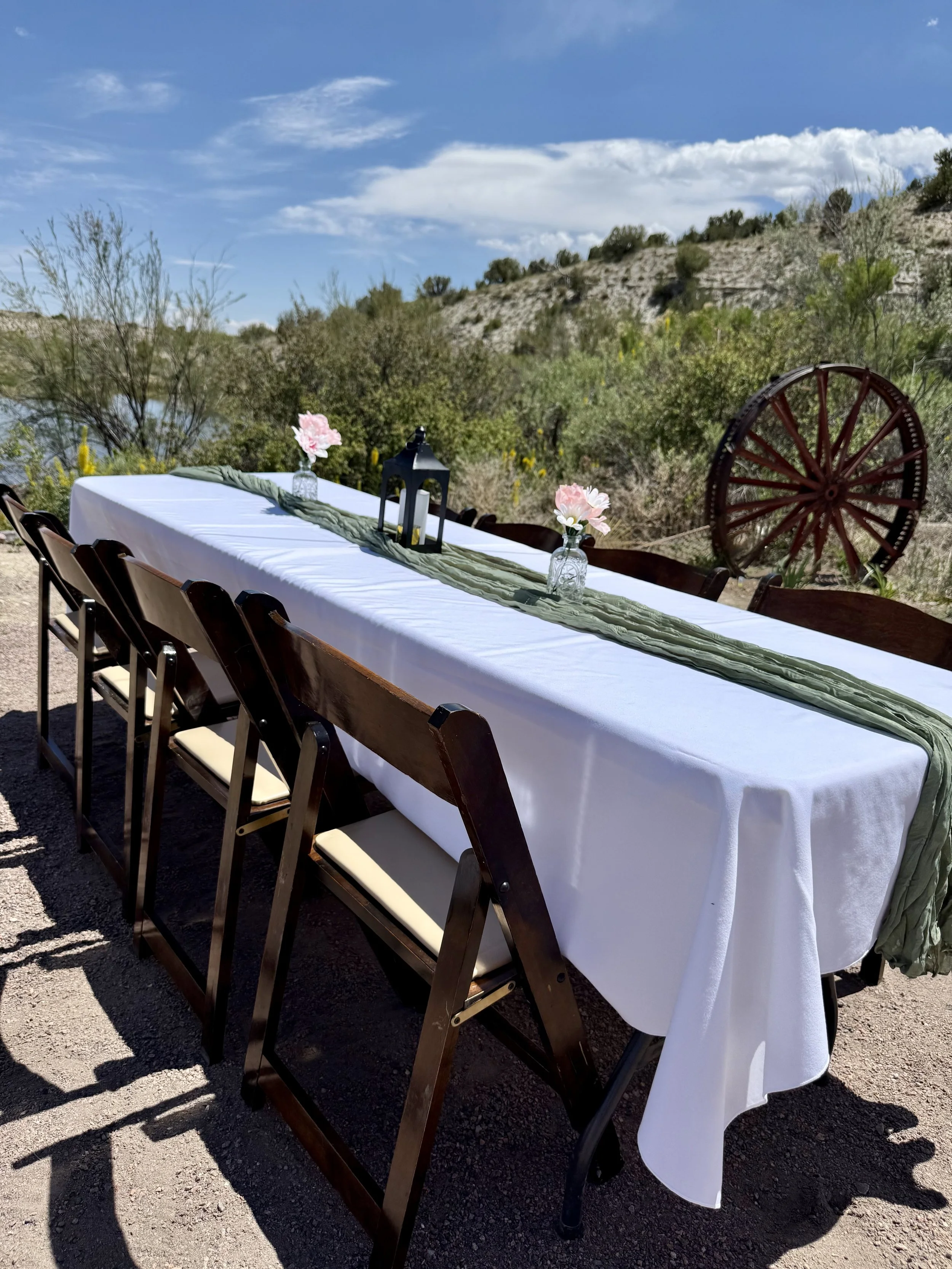 Outdoor wedding reception by the pond with mountain in the background at waterfront wedding venue near Pueblo, Colorado. Lost Pond is a rustic garden wedding venue with wildflowers and natural water features.